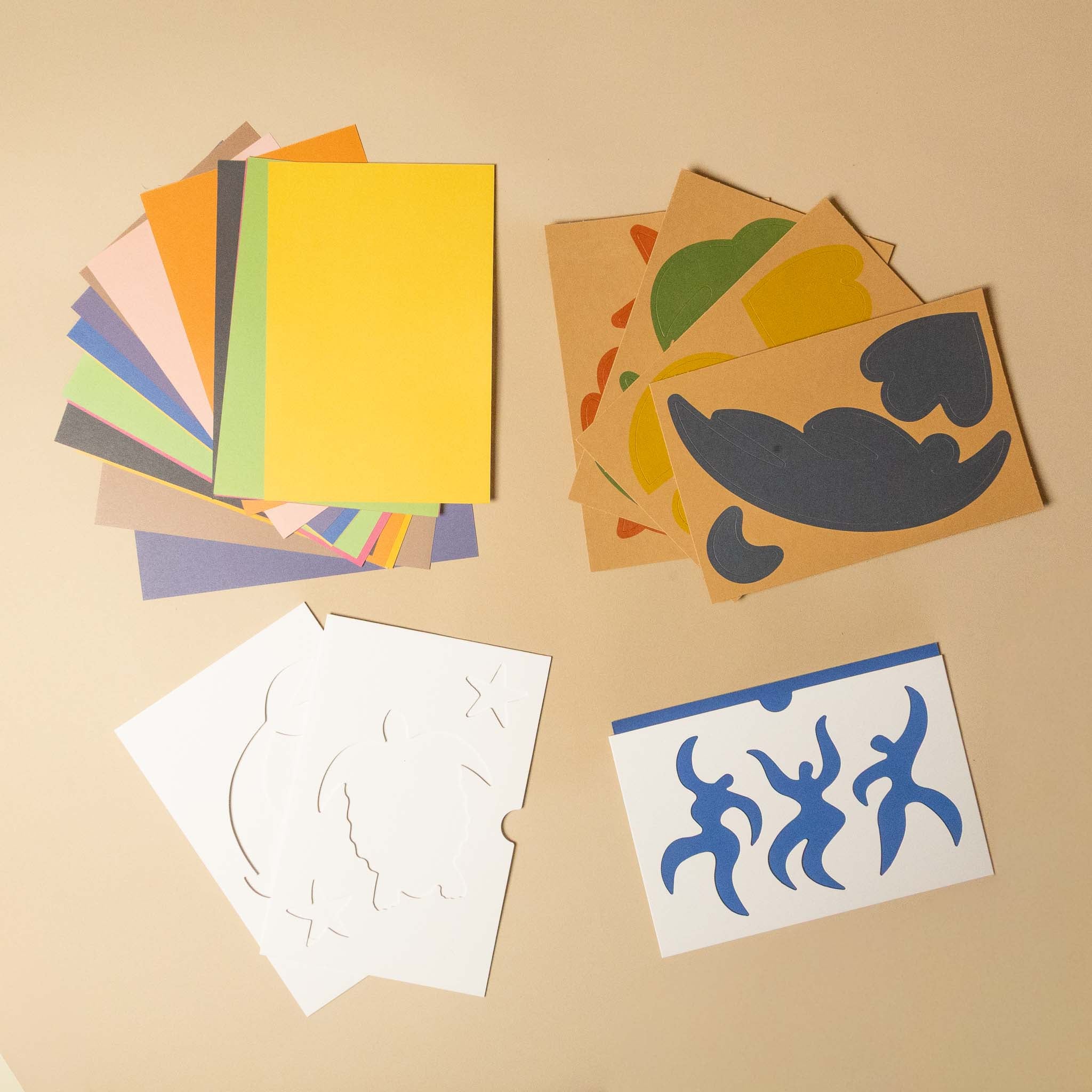 play-with-matisse-creative-activity-kit Colorful paper cutouts and templates on a beige surface