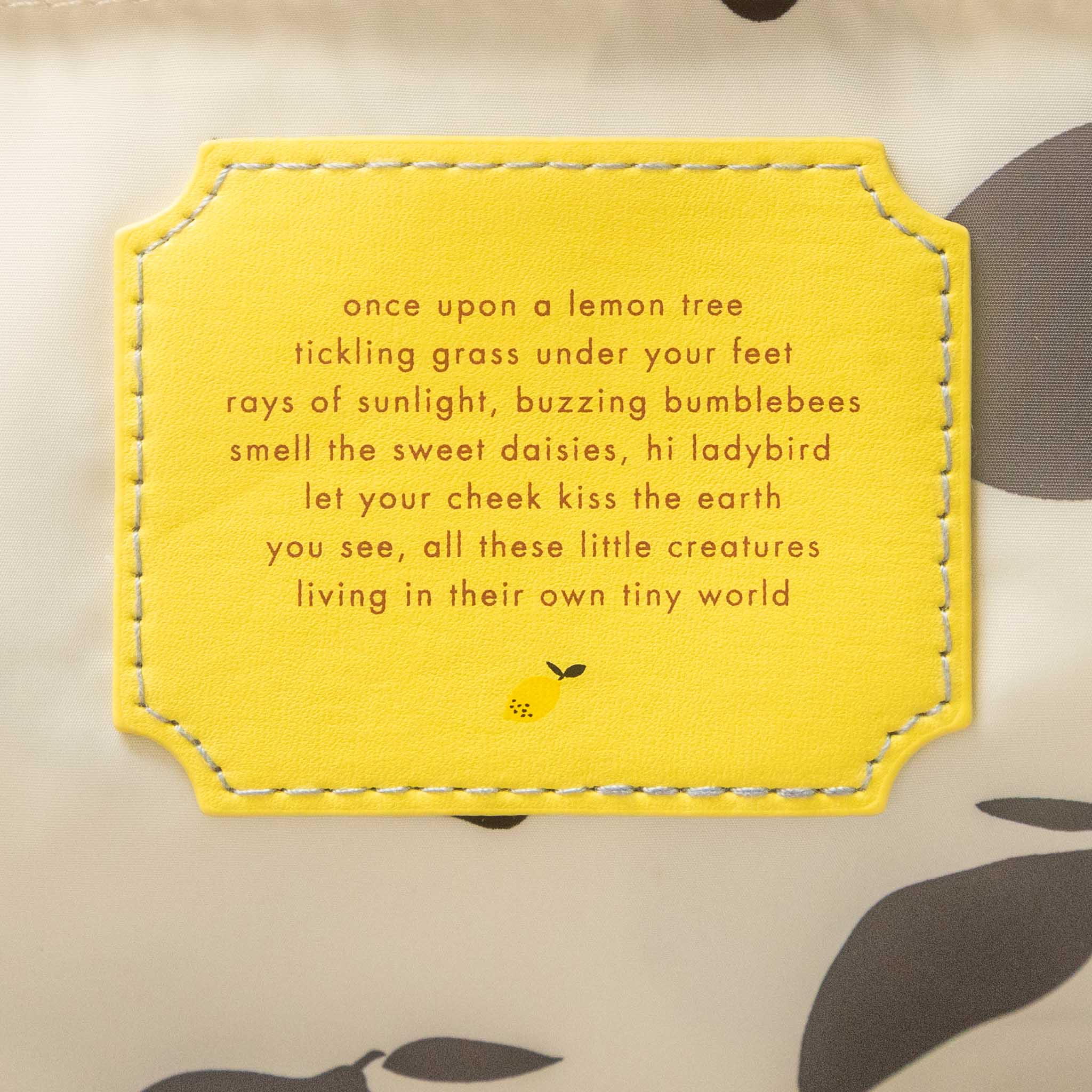 Yellow embroidered patch with a poem on a fabric background