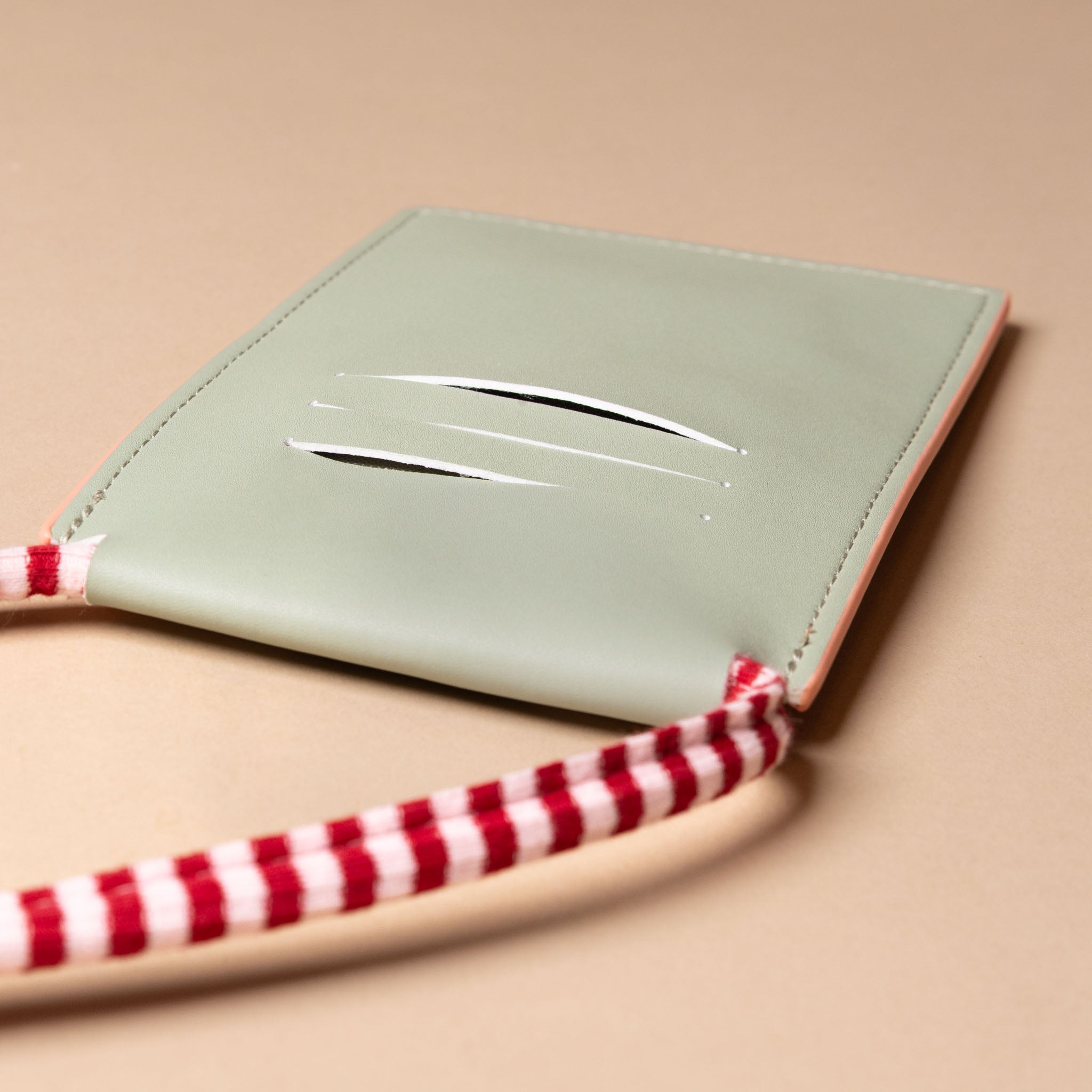 recycled-wonders-phone-pouch-coral-pink-with-red-and-white-striped-strap-back-with-card-holding-slot