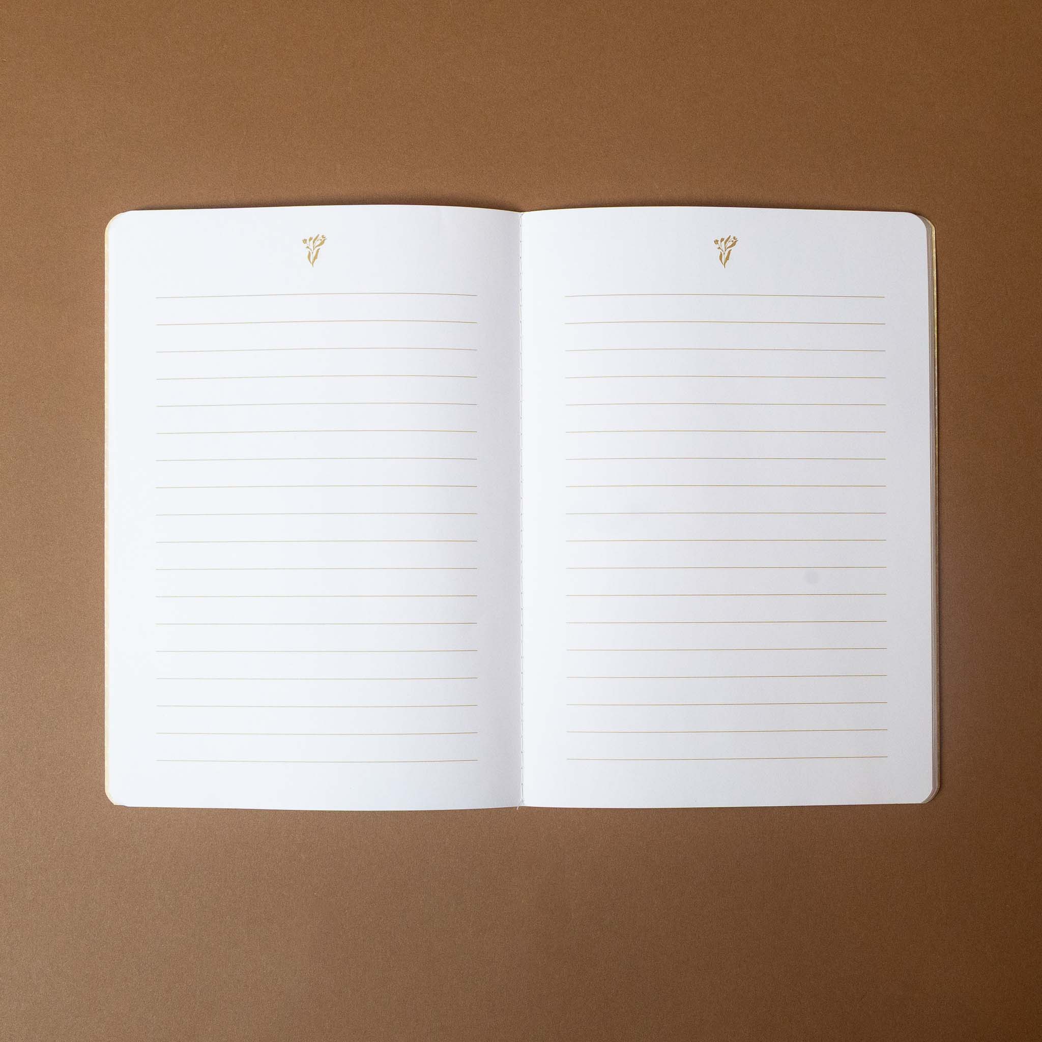 reverie-floral-notebook-ferns Open notebook with lined pages on a brown background