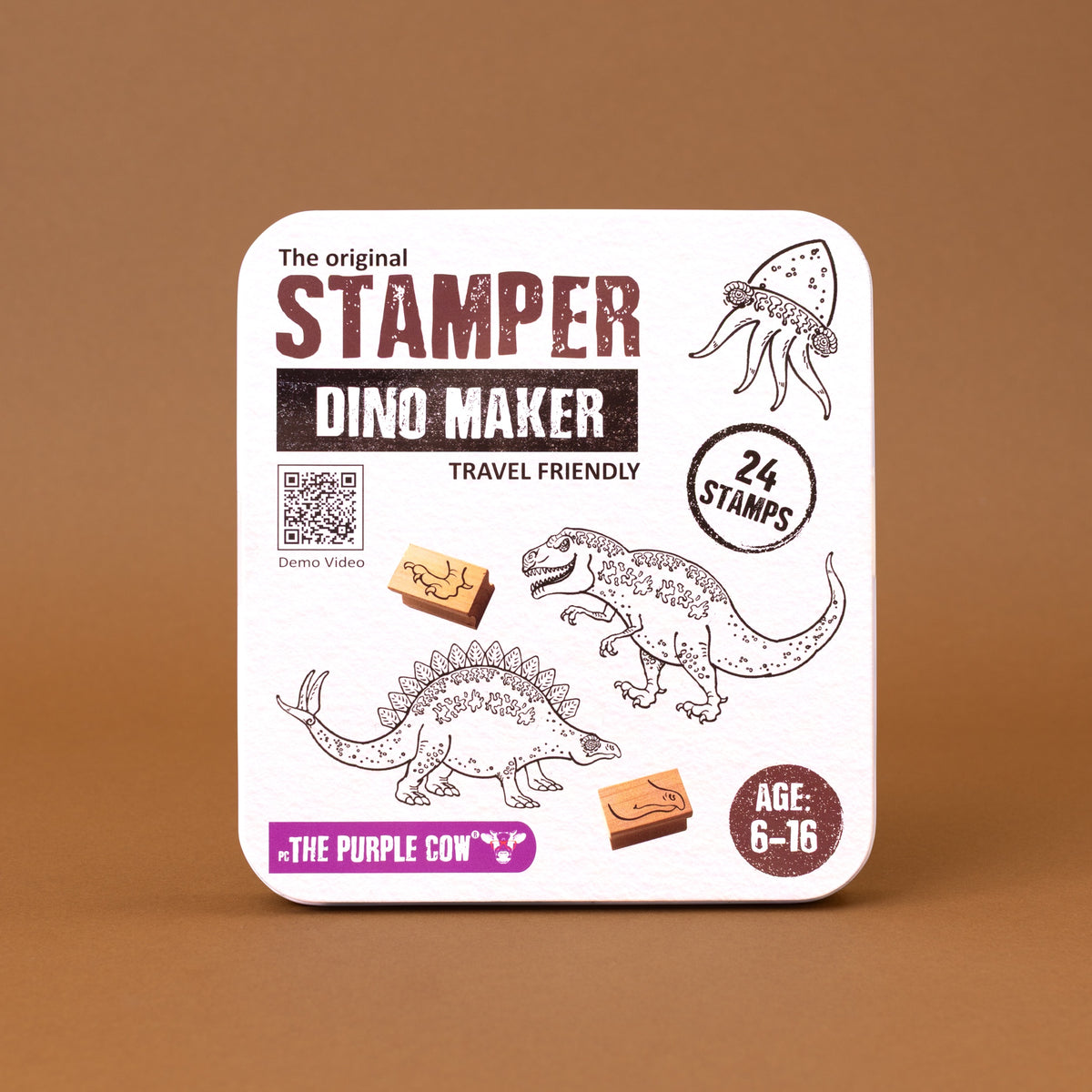 The original Stamper Dino Maker travel-friendly stamp set in a square tin with rounded corners, featuring dinosaur illustrations and product details on a brown background.