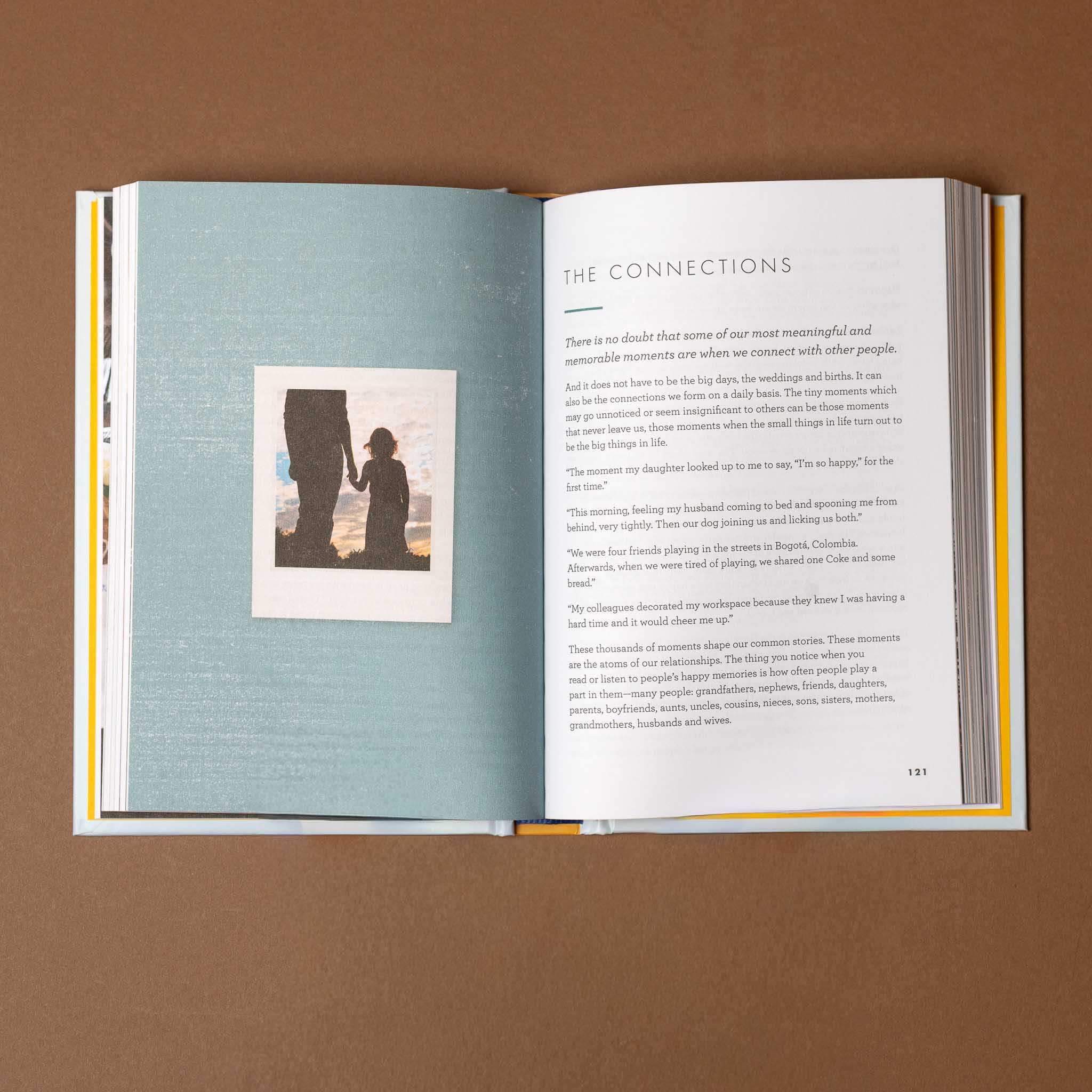 the-art-of-making-memories Open book on a brown background with text and a silhouette image