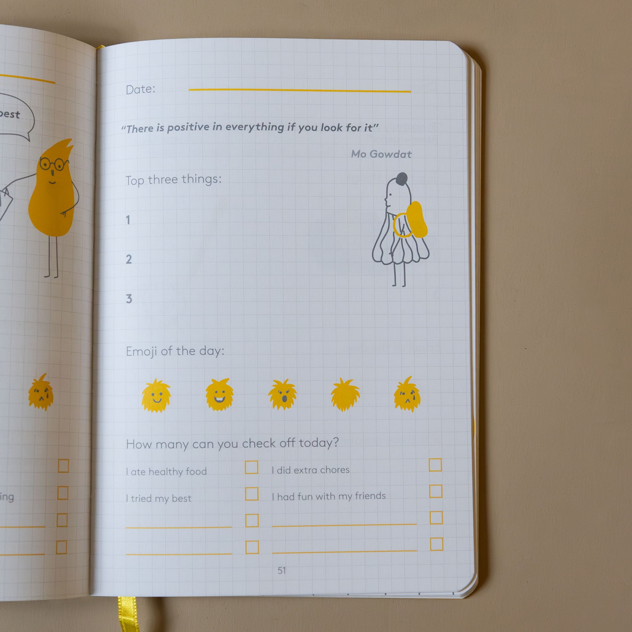 Open yellow-the-happyme-journal-junior with illustrated pages on a beige background