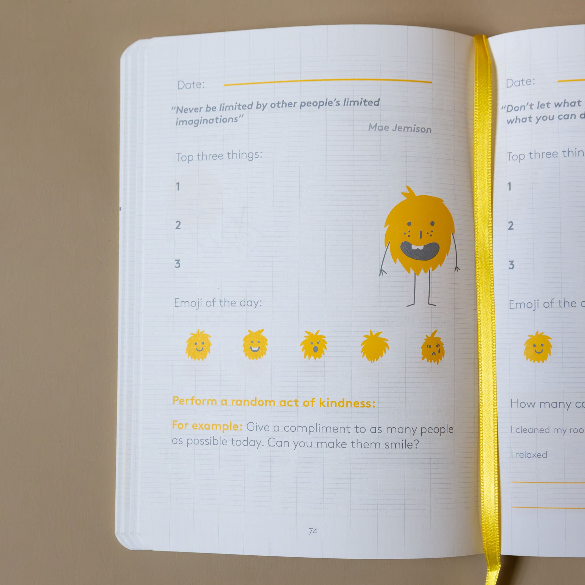 Open yellow-the-happyme-journal-junior with emoji illustrations and motivational text on a beige background