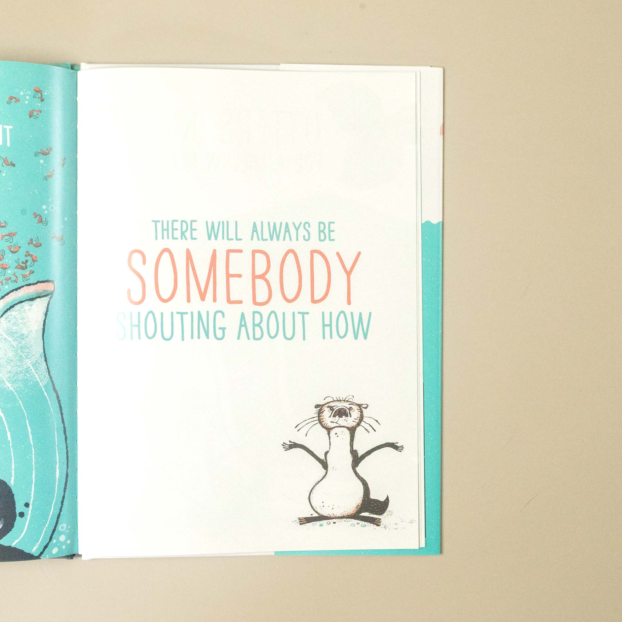 An open book or card on a beige surface showing a quote that reads 'THERE WILL ALWAYS BE SOMEBODY SHOUTING ABOUT HOW' in teal and coral text, with a small black-and-white cartoon animal at the bottom and turquoise side panels.