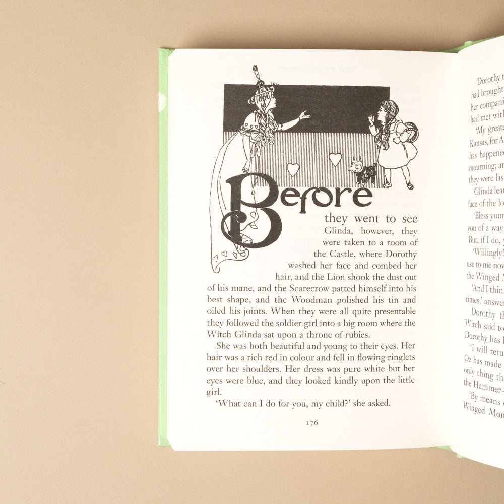 the-wizard-of-oz Open book with illustrations and text on a beige background