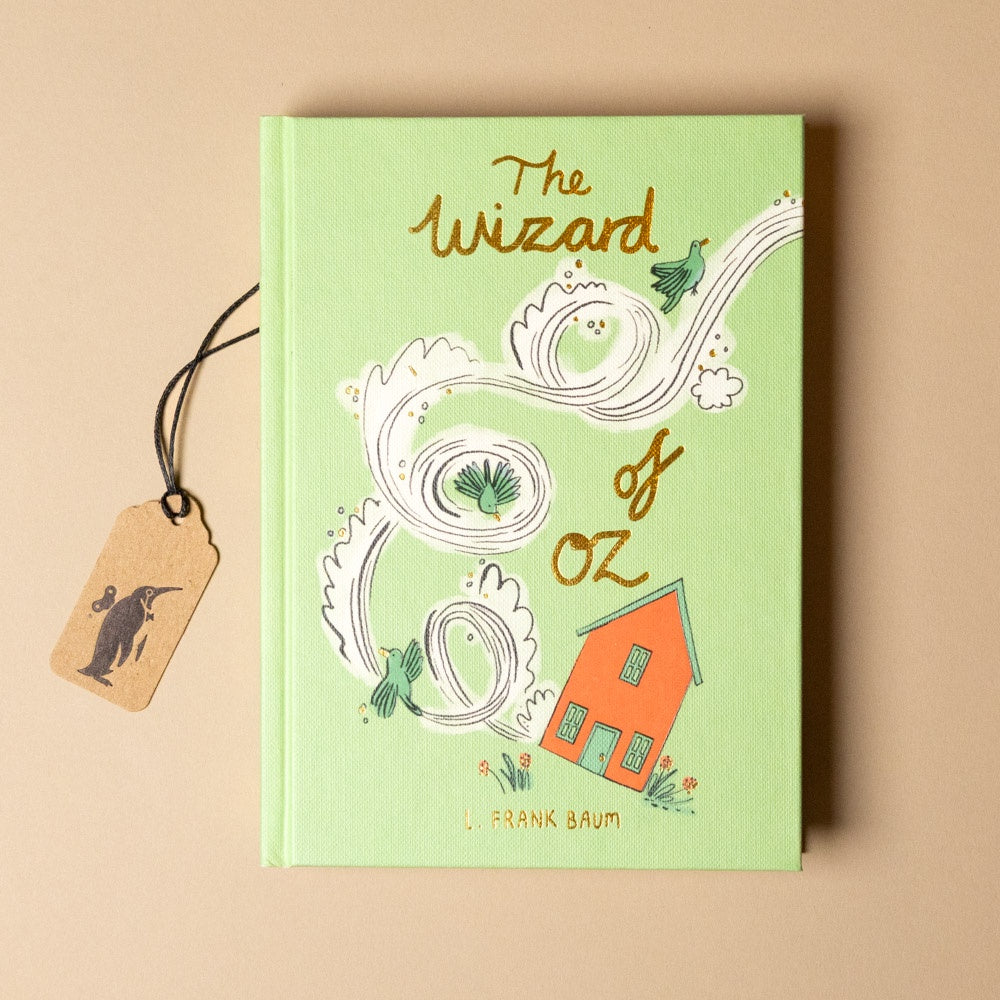 Book titled 'The Wizard of Oz' with a decorative tag on a beige background