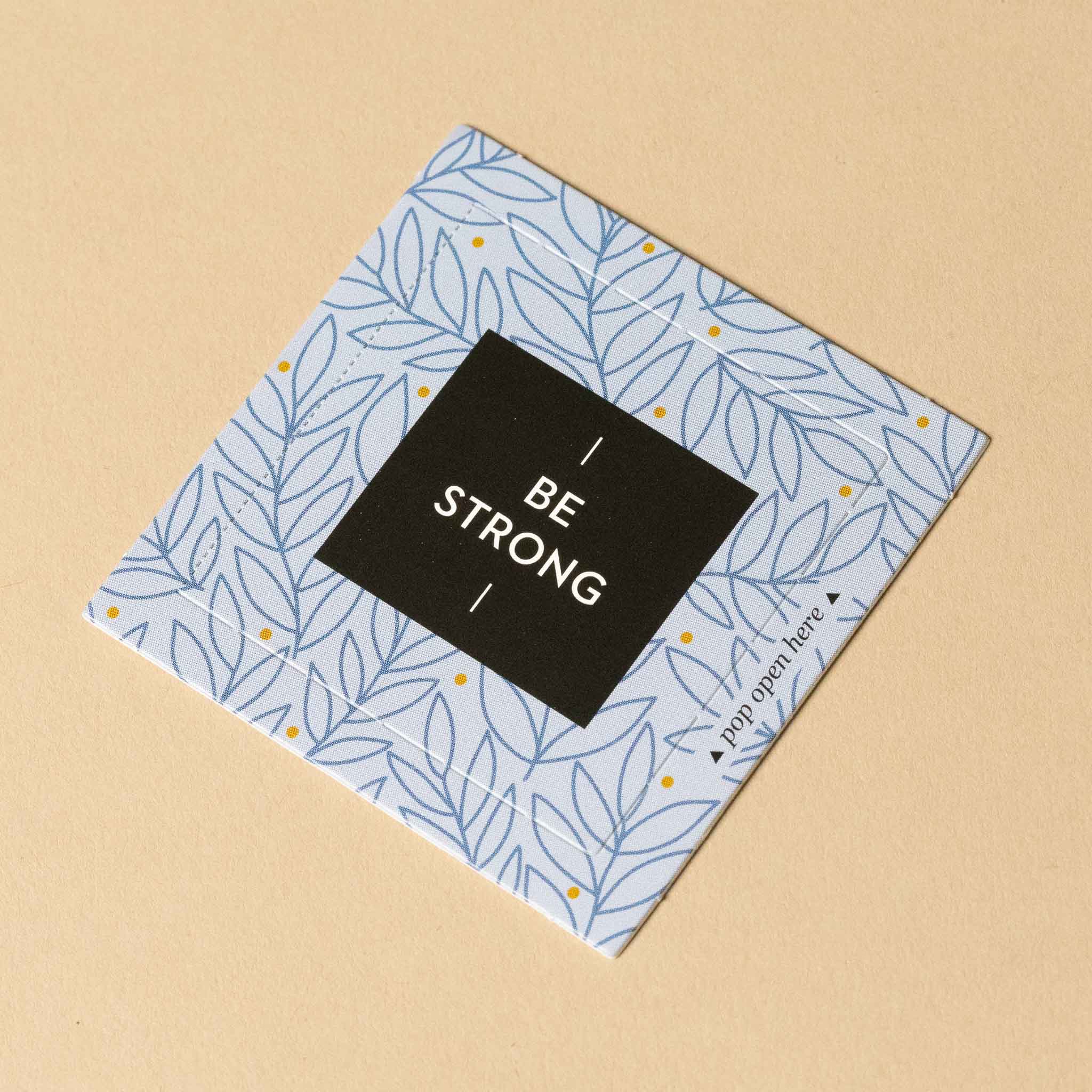 thoughtfulls-pop-open-cards-be-strong Notebook with 'Be Strong' message on a beige background