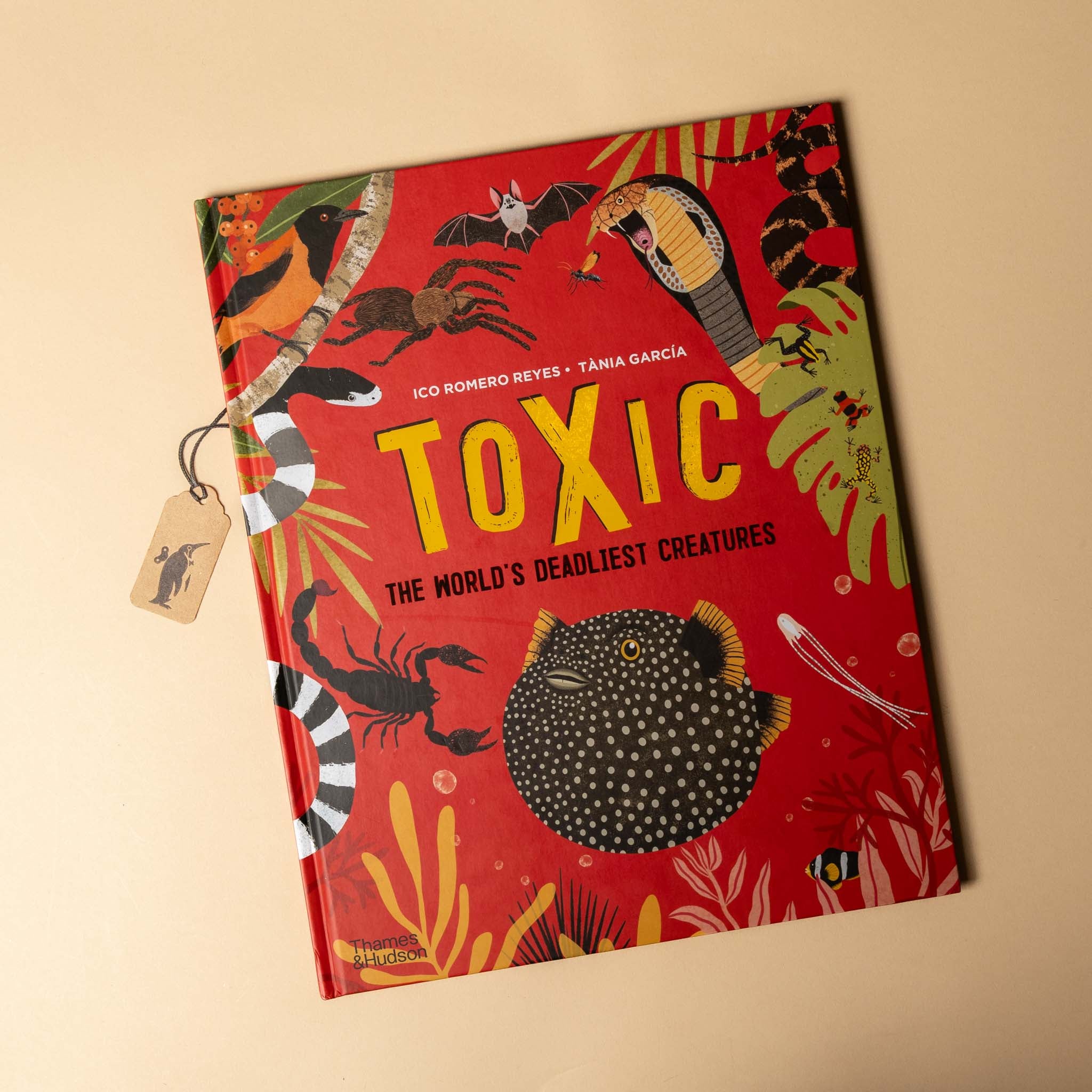 Book titled 'Toxic: The World's Deadliest Creatures' with colorful illustrations on a beige background
