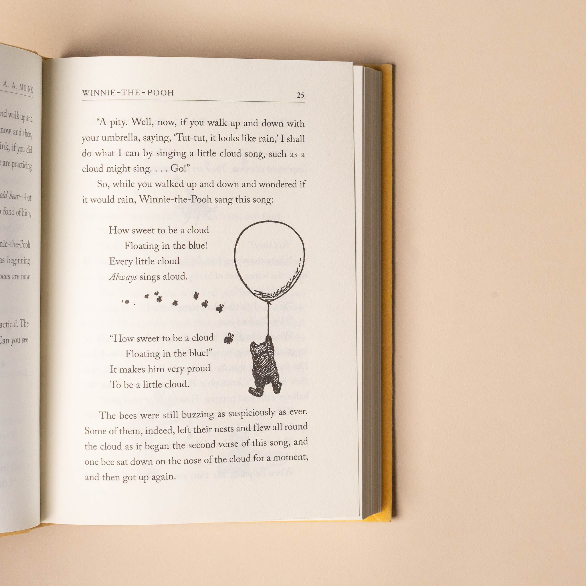 Open winnie-the-pooh-100th-anniversary-edition book with a page featuring text and an illustration of a bear with a balloon on a beige background