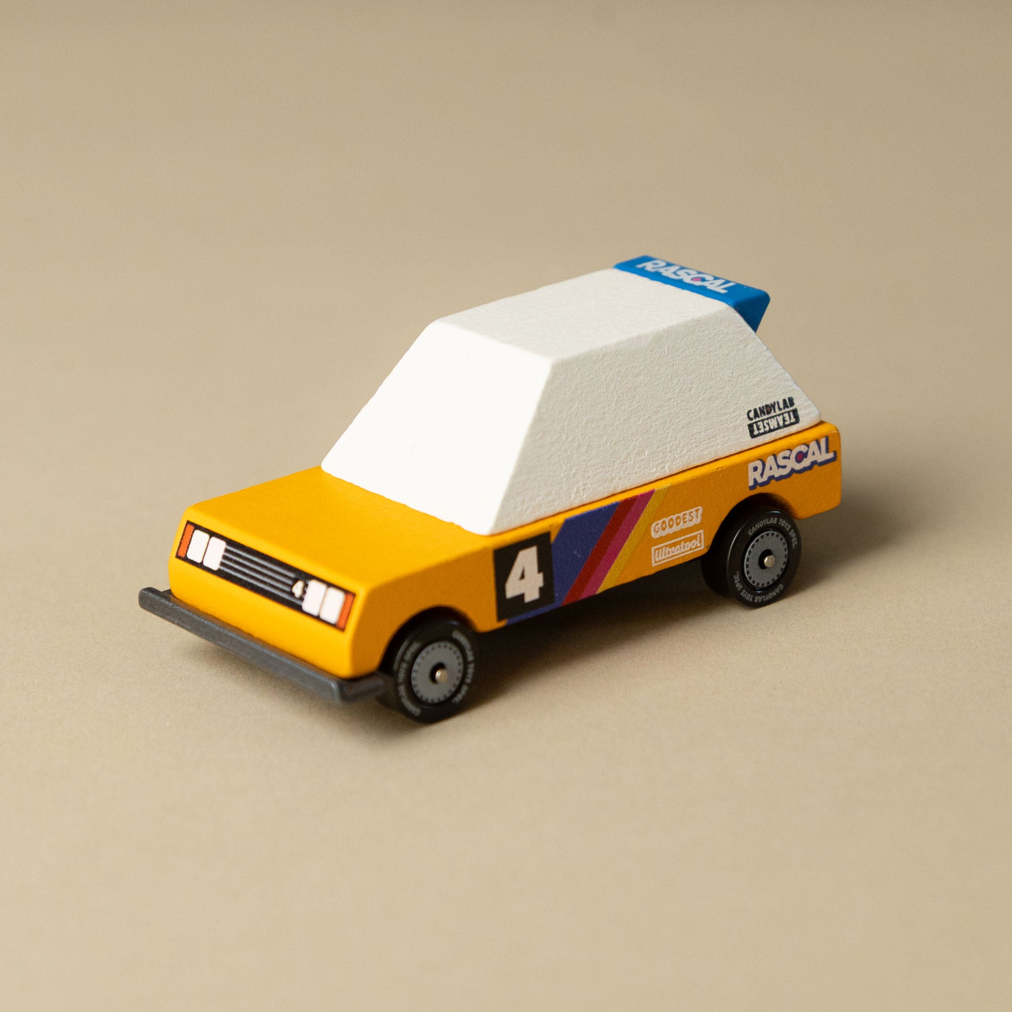 wooden-candycar-toon-4-pack-tokyo-heat Toy orange car model on a beige background