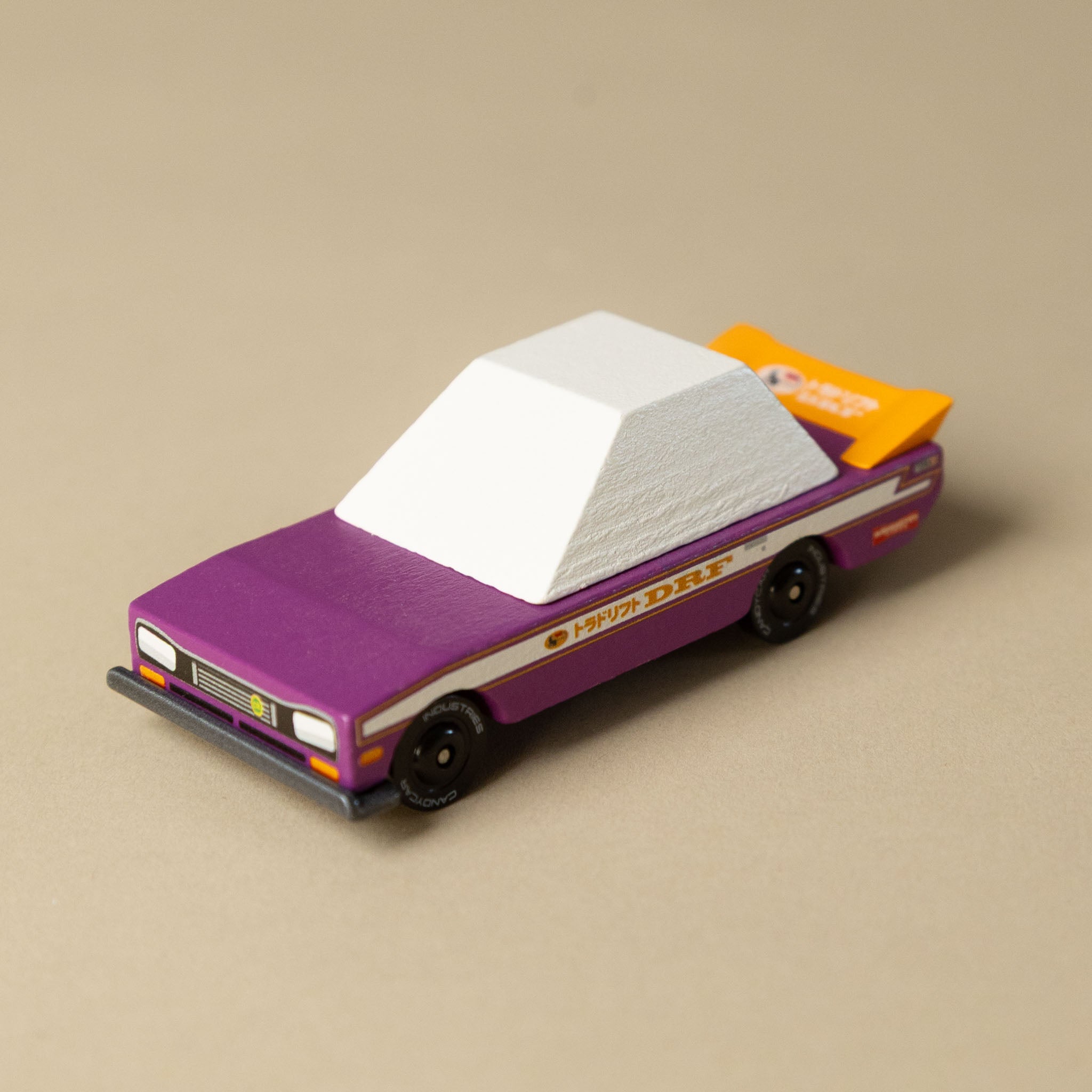 wooden-candycar-toon-4-pack-tokyo-heat Model car with purple body and white roof on a beige background