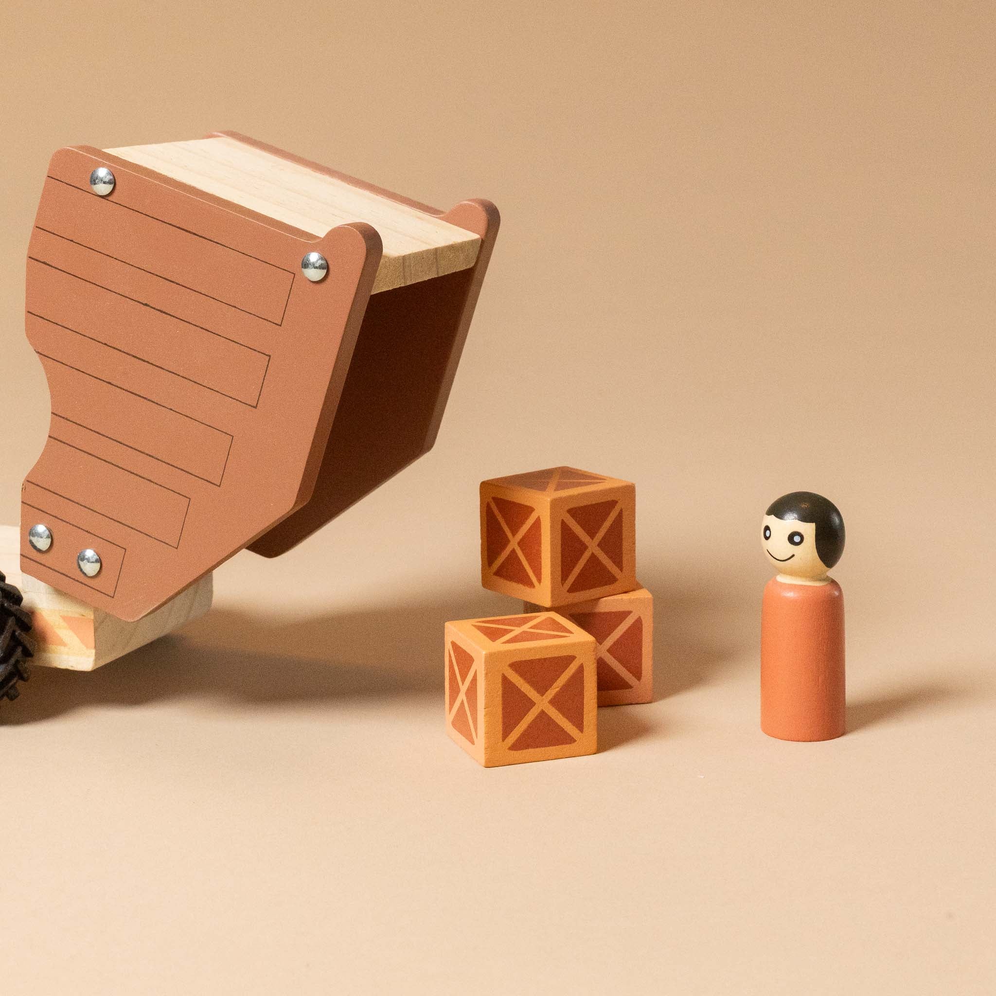 wooden-dump-truck with blocks, and a figurine on a beige background