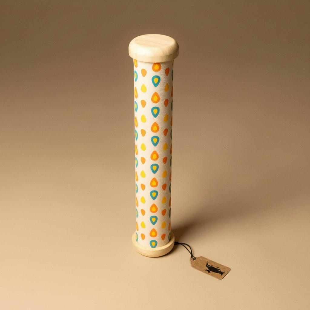 Cylindrical wooden-rainmaker-stick with a patterned design on a beige background