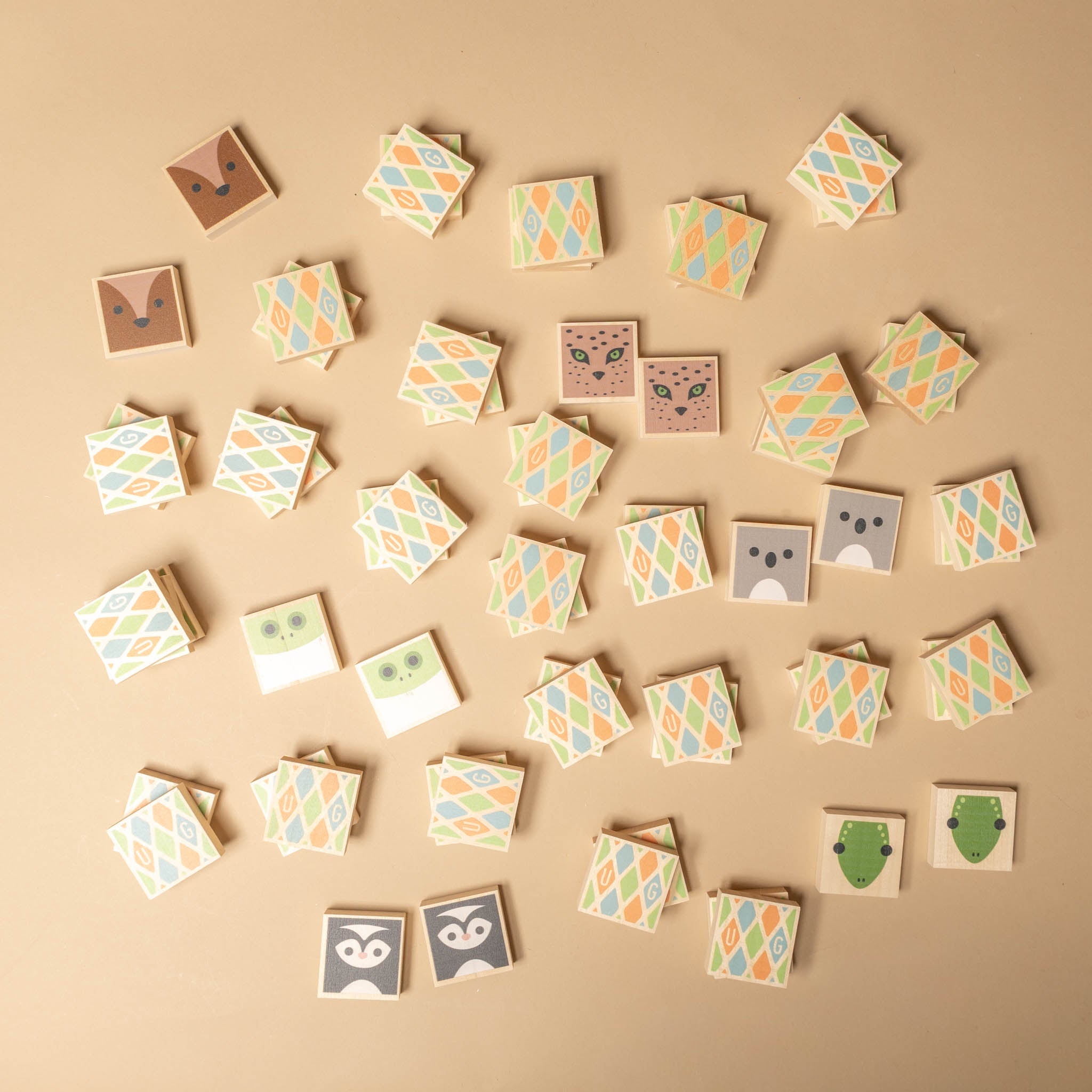 wooden-squarimals-memory-game Collection of small square tiles with animal faces on a beige background