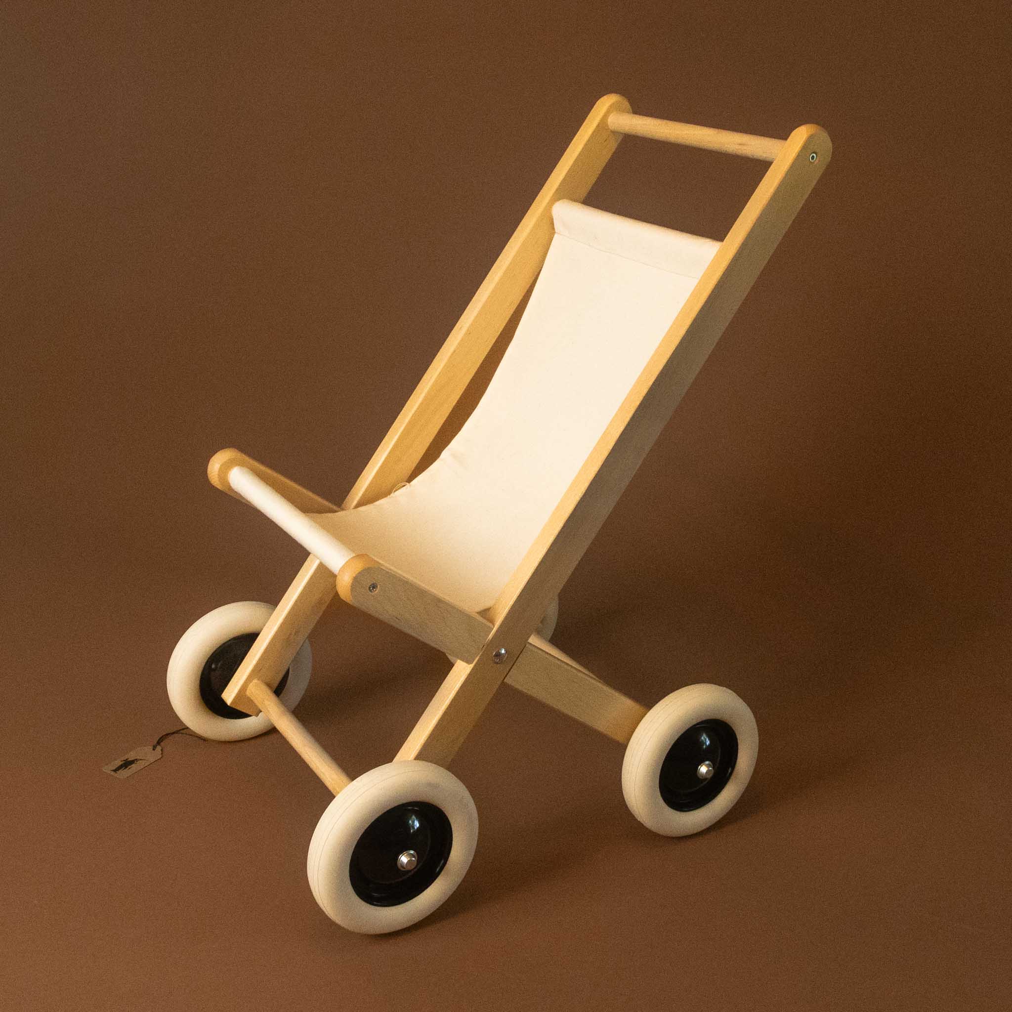 Wooden toy stroller with white seat on a brown background