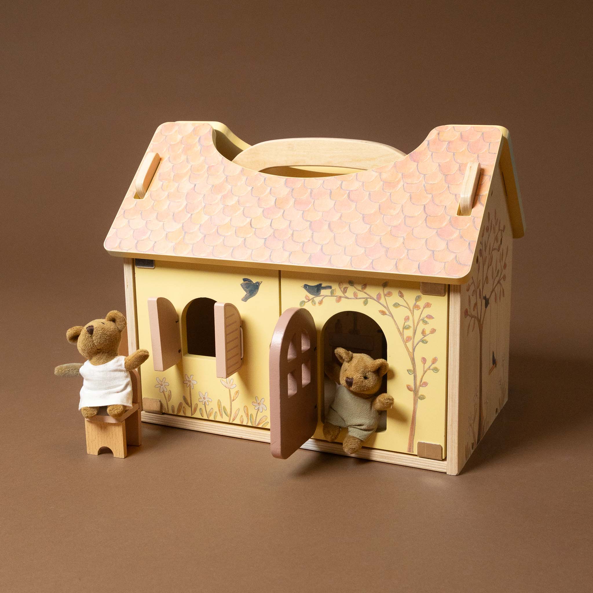 Wooden toy house with teddy bears on a brown background