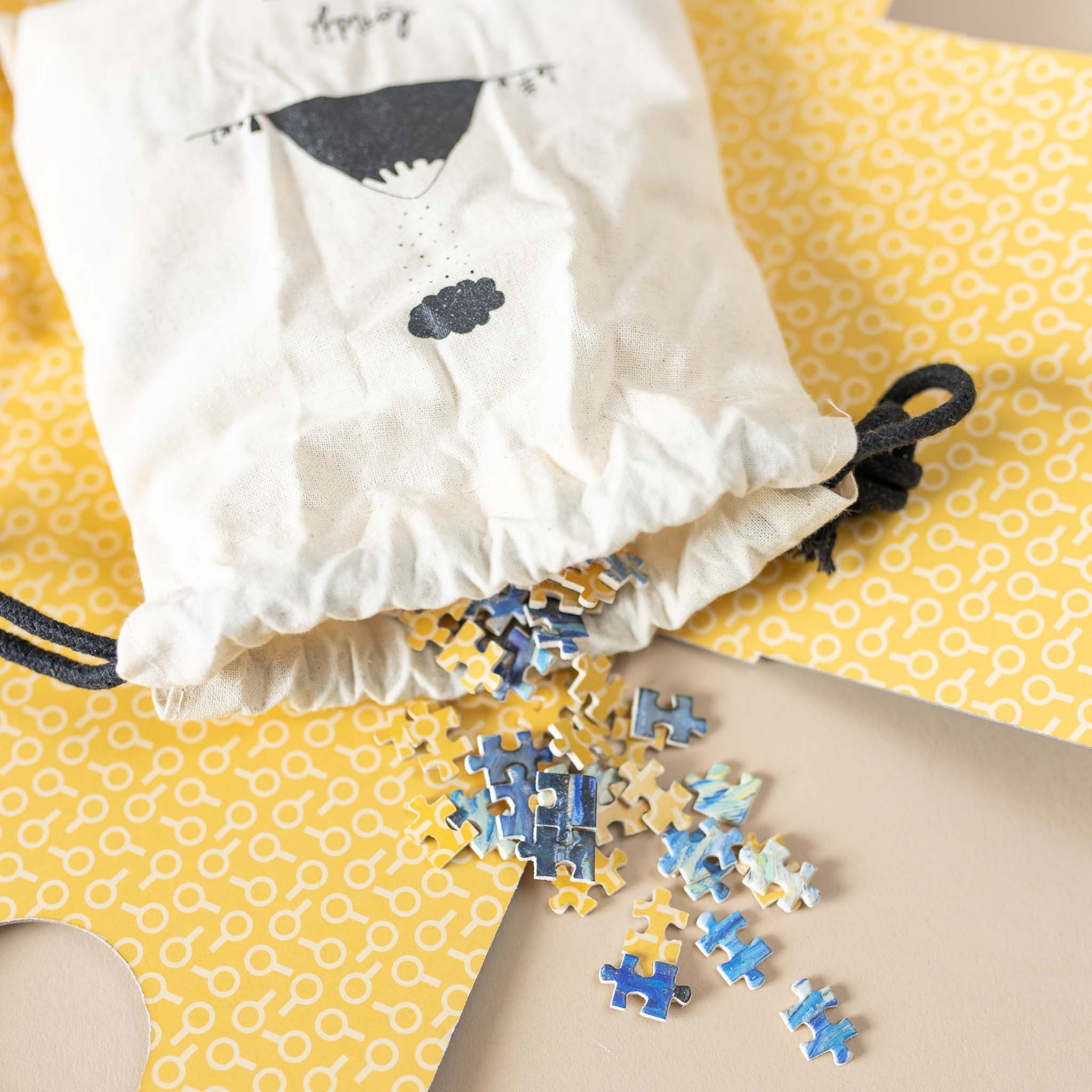 close-up-starry-night-puzzle-pieces-and-cloth-storage-bag