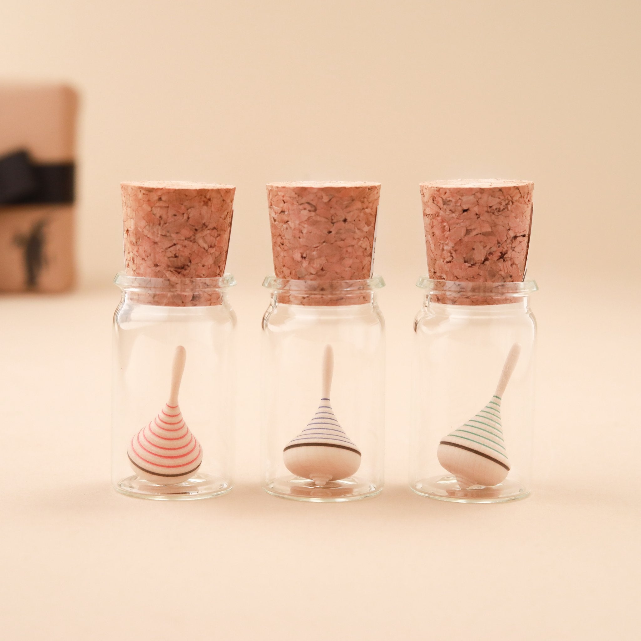 spinning-top-glass-display-colored-stripe-wooden-top
