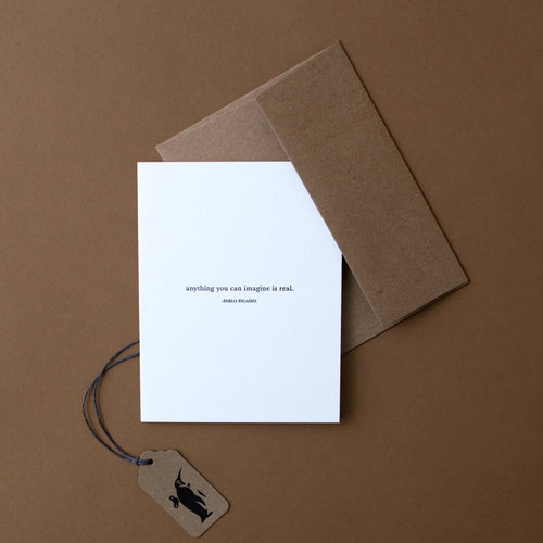 white-greeting-card-with-the-text-anything-you-can-imagine-is-real-and-craft-paper-envelope