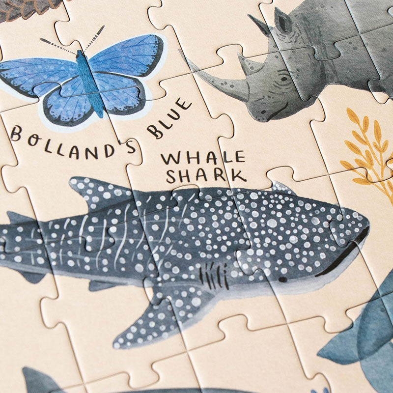 200-piece-life-puzzle with whale shark, butterfly, and rhino pieces on a beige background