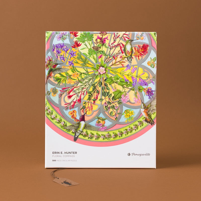 ErinE.Hunter_sFloralCompass500pcCircularPuzzle, featuring a highly detailed, colorful botanical and floral pattern on the cover, set against a solid brown background.