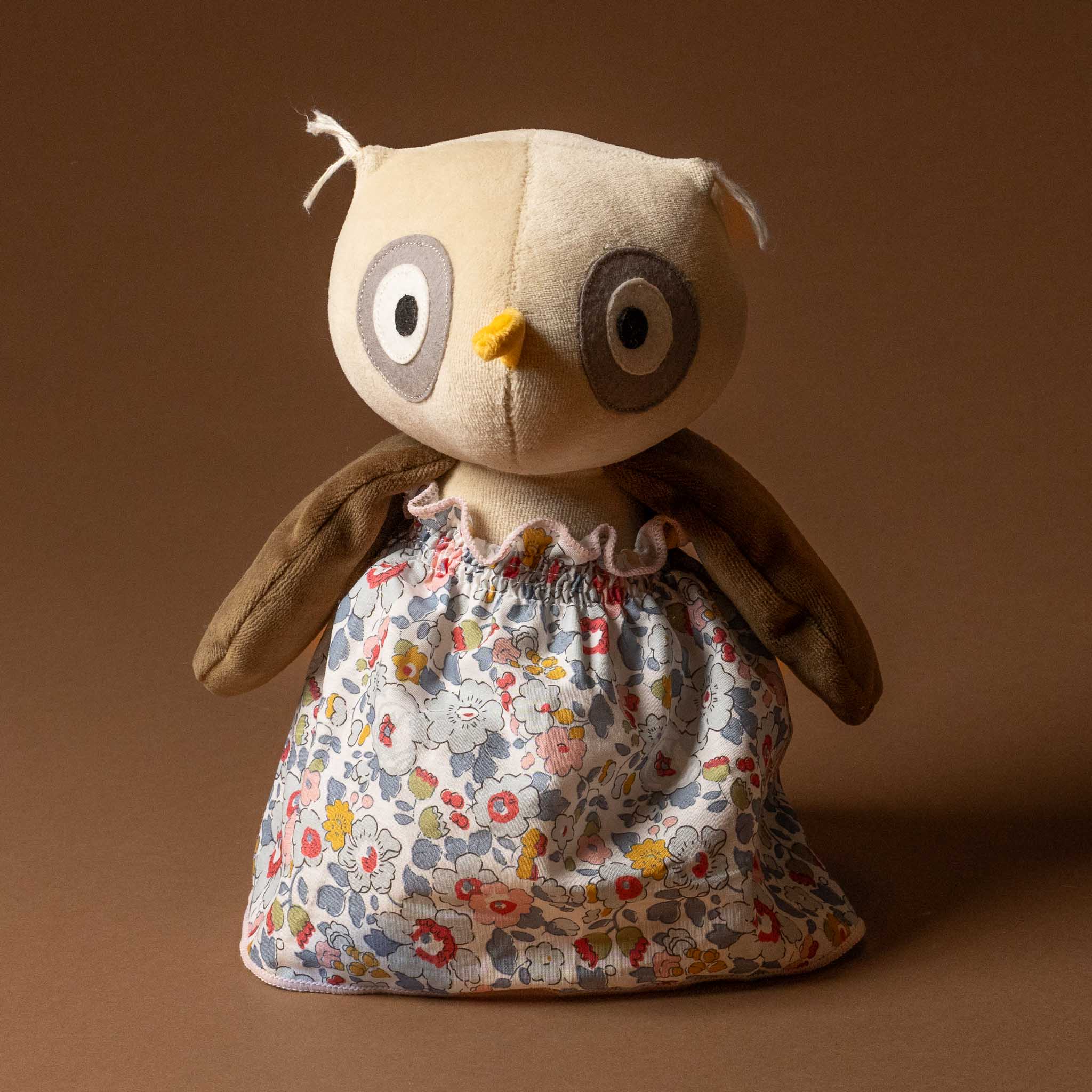 Stuffed owl toy with a Grande-Outfit-Liberty-Dress-Grey-_-Blue on a brown background