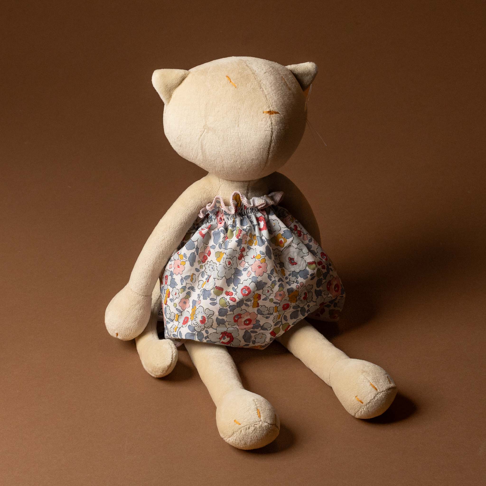Stuffed animal toy with a Grande-Outfit-Liberty-Dress-Grey-_-Blue on a brown background