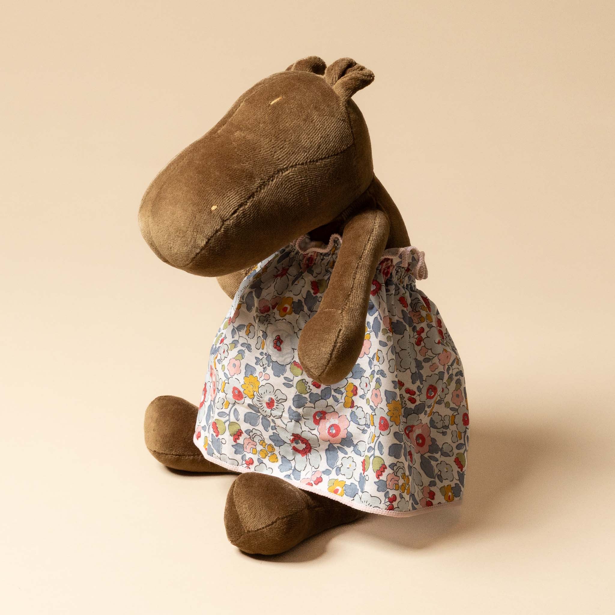 Stuffed animal wearing a Grande-Outfit-Liberty-Dress-Grey-_-Blue on a beige background