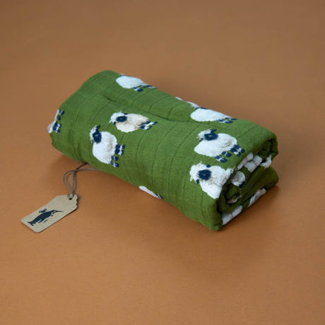 bamboo-swaddle-valais-sheep-green-background-with-black-and-white-sheep