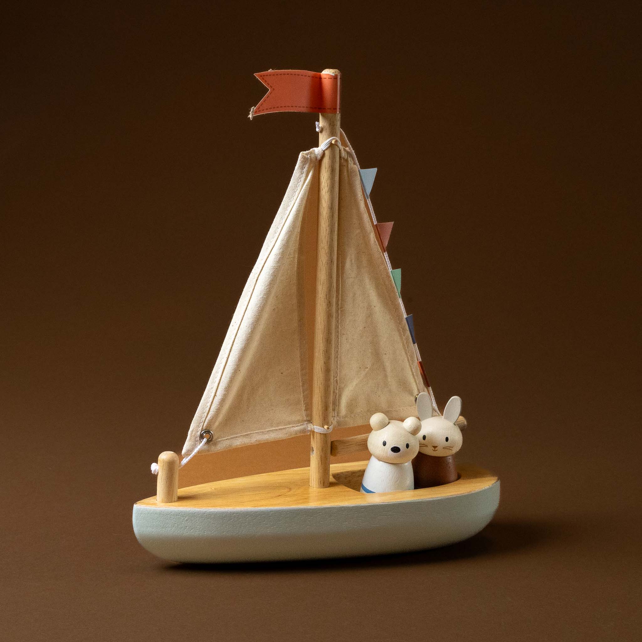 Wooden-Sailway-Boat with a red flag and two animal figures on a brown background