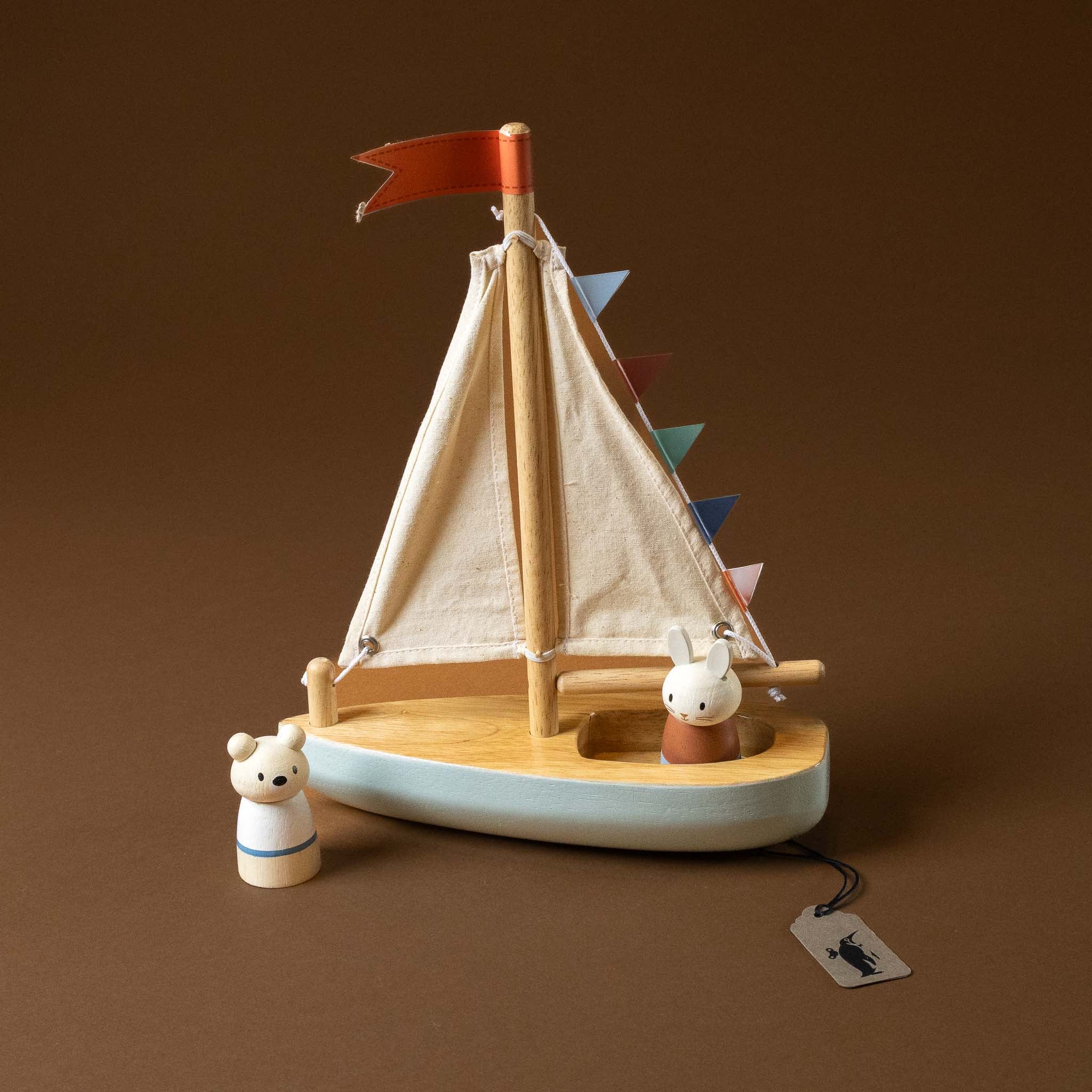Wooden-Sailway-Boat with a red flag and colorful pennants on a brown background