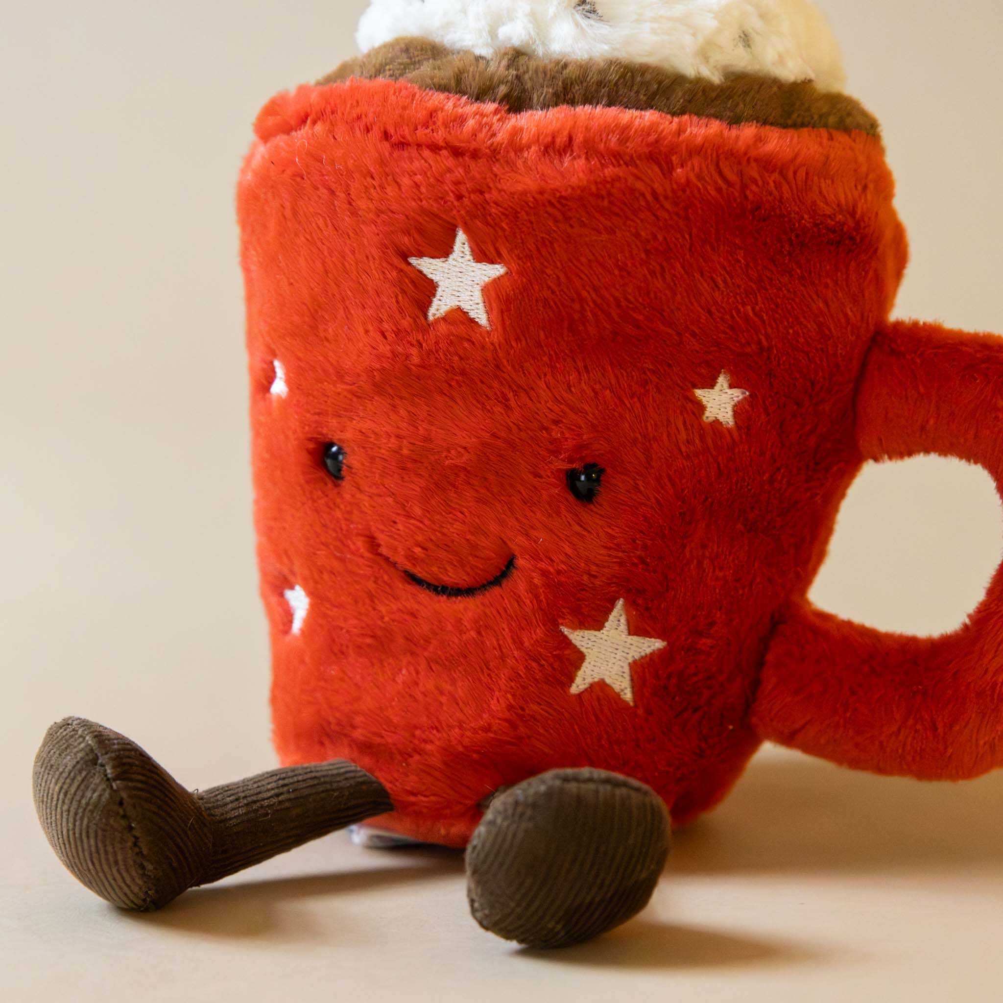 star-covered-red-mug-hot-chocolate-stuffed-animal-and-corduroy-brown-legs 