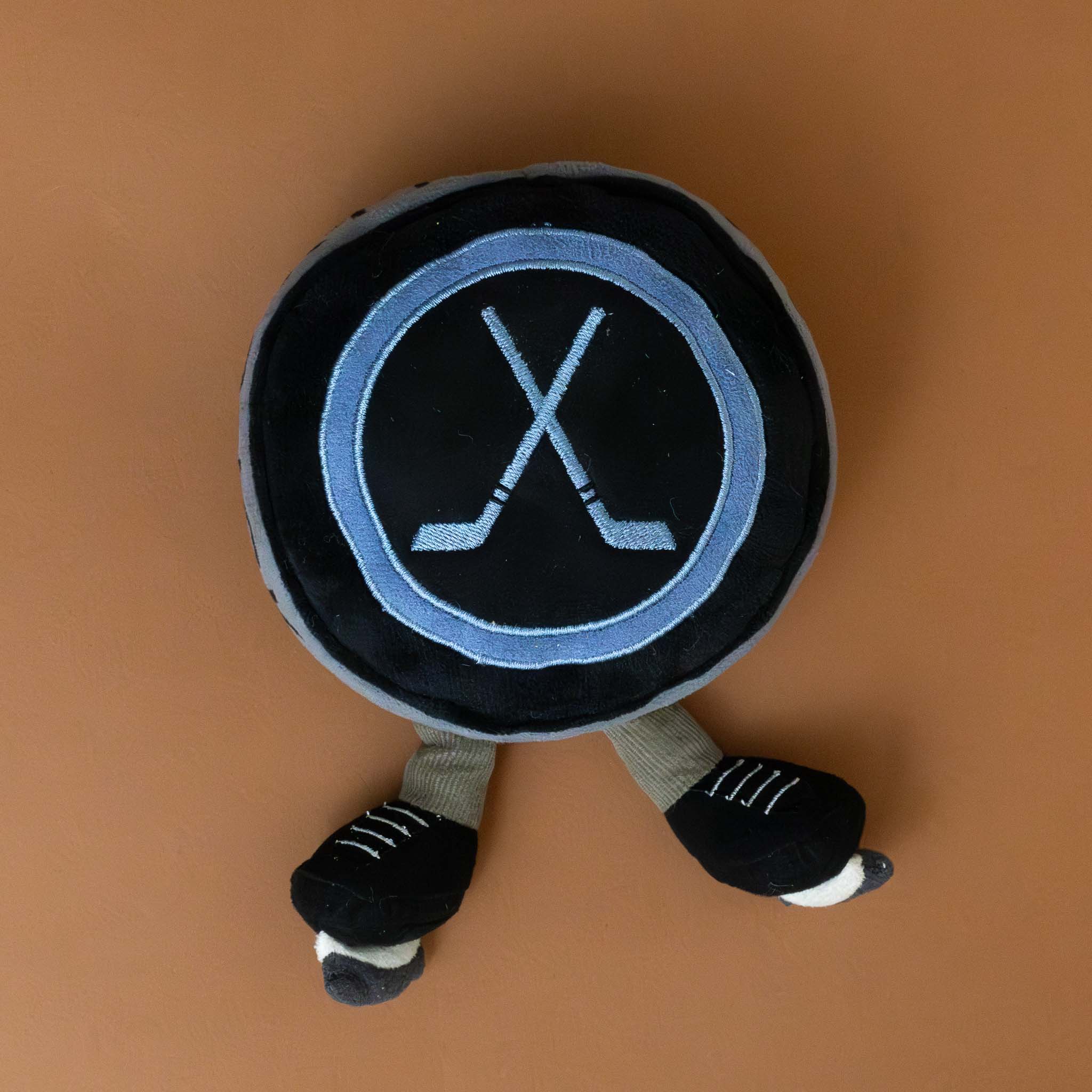 amuseable-sports-ice-hockey-puck-black-and-grey-with-ice-skate-feet-stuffed-toy-two-crossed-hockey-sticks-on-top