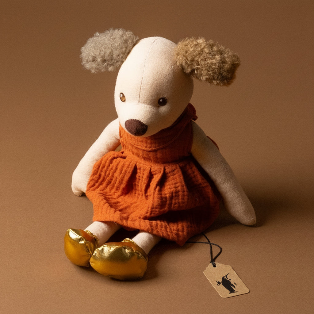 amy-the-puppy Stuffed animal toy with a orange dress and gold shoes on a brown background
