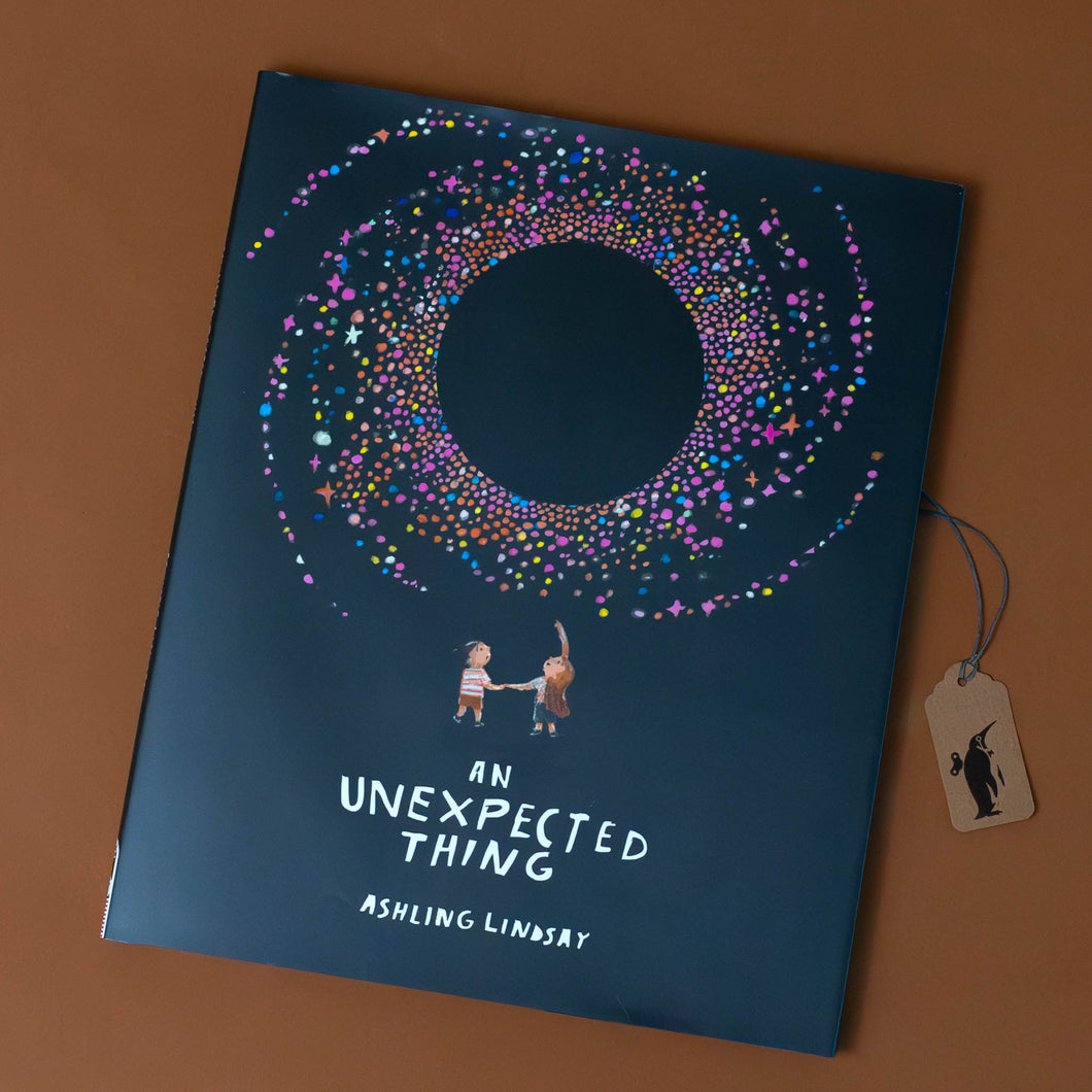 an-unexpected-thing-black-cover-with-two-children-pointing-at-a-colorful-swirl