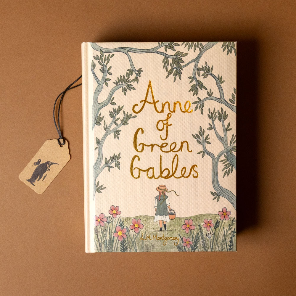 Book titled 'Anne of Green Gables' with a decorative cover and tag on a brown background