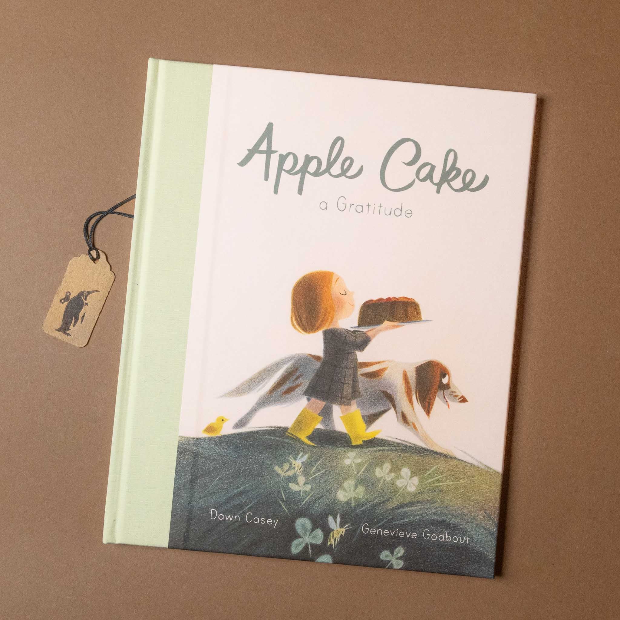 Book titled 'Apple Cake' with a child and dog illustration on a brown background