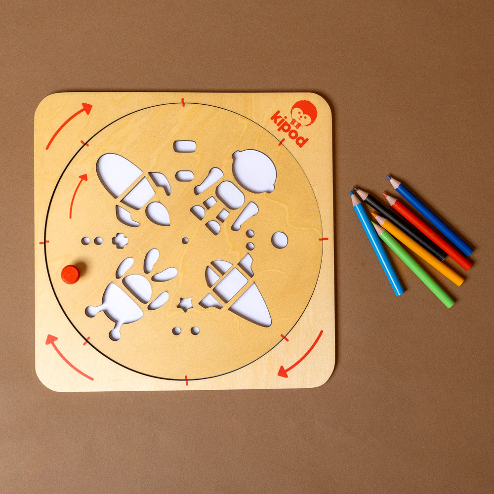 artwist-art-kit-space with-colorful-drawings Wooden activity board with, accompanied by colorful pencils on a brown background.