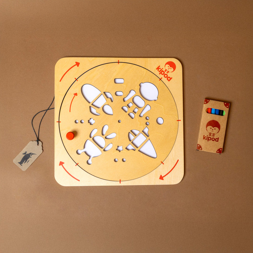 artwist-art-kit-space with-colorful-drawings Wooden activity board with, accompanied by colorful pencils on a brown background.