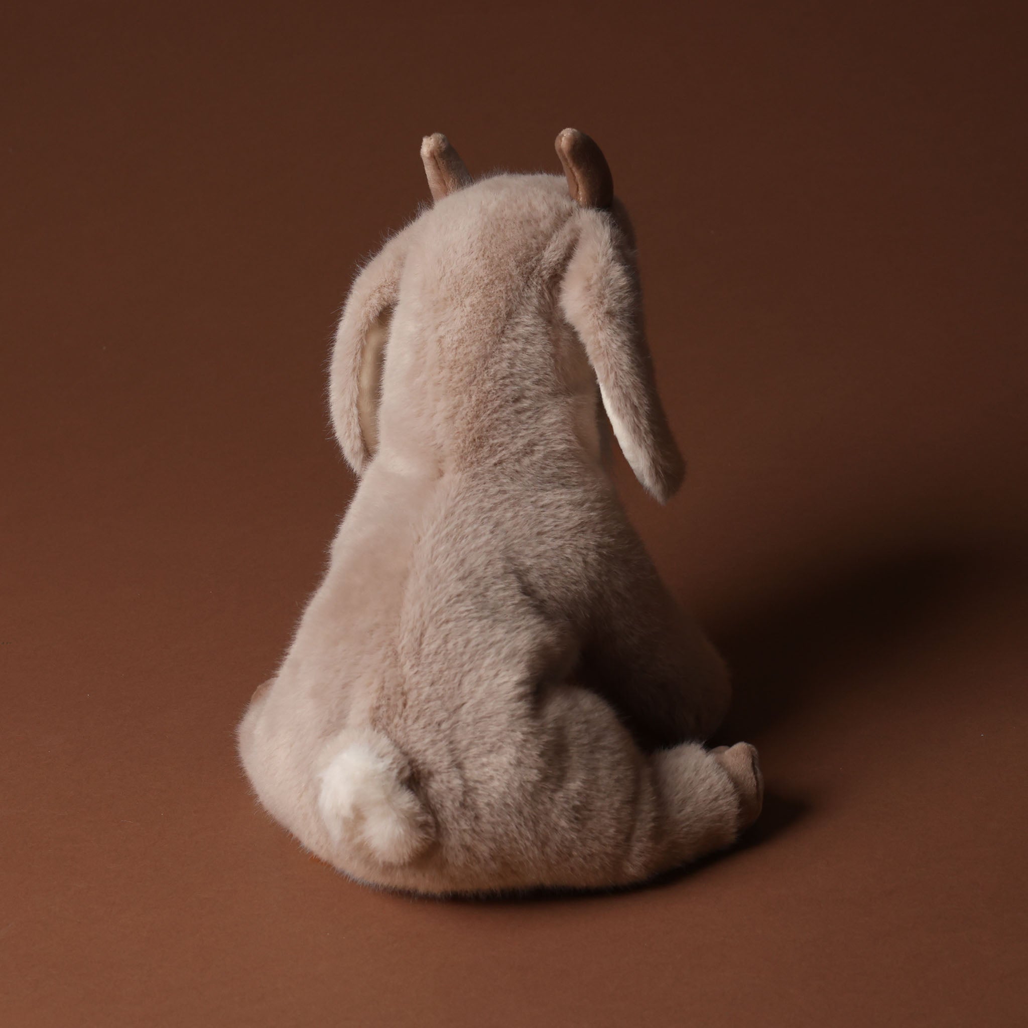 Plush toy beardie-the-billy-goat on a brown background