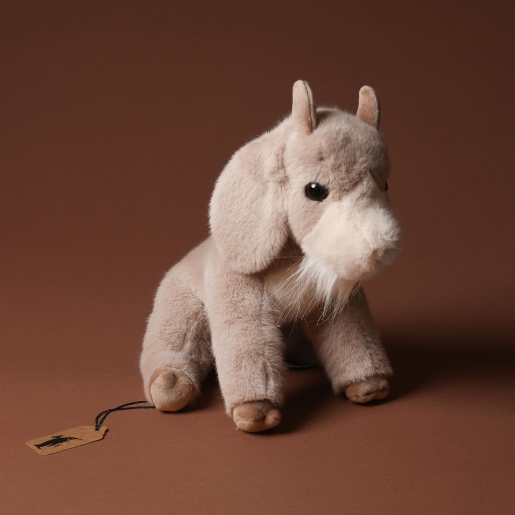 Plush toy beardie-the-billy-goat on a brown background