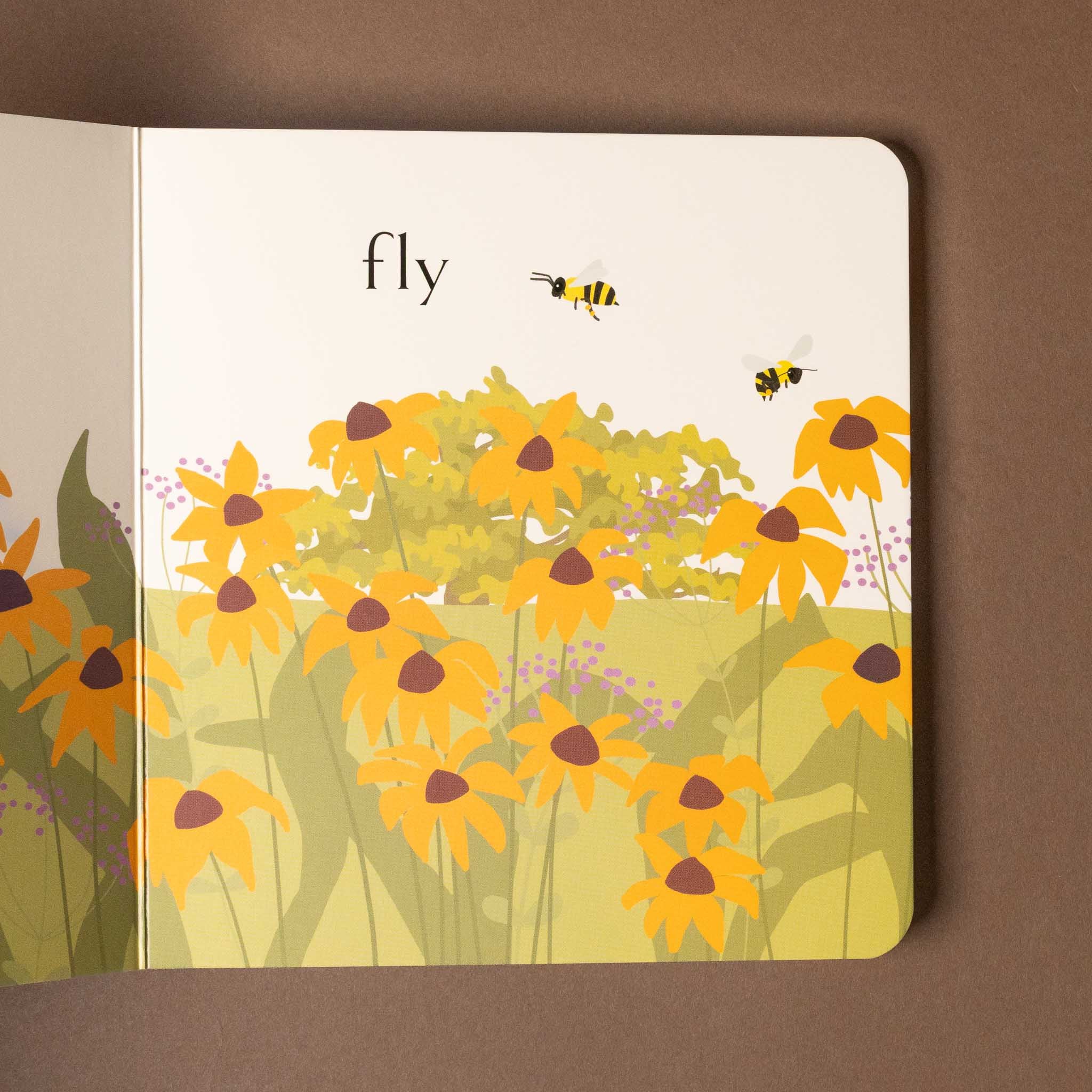 Illustration of yellow flowers and bees on a beehive-board-book with the word 'fly'.
