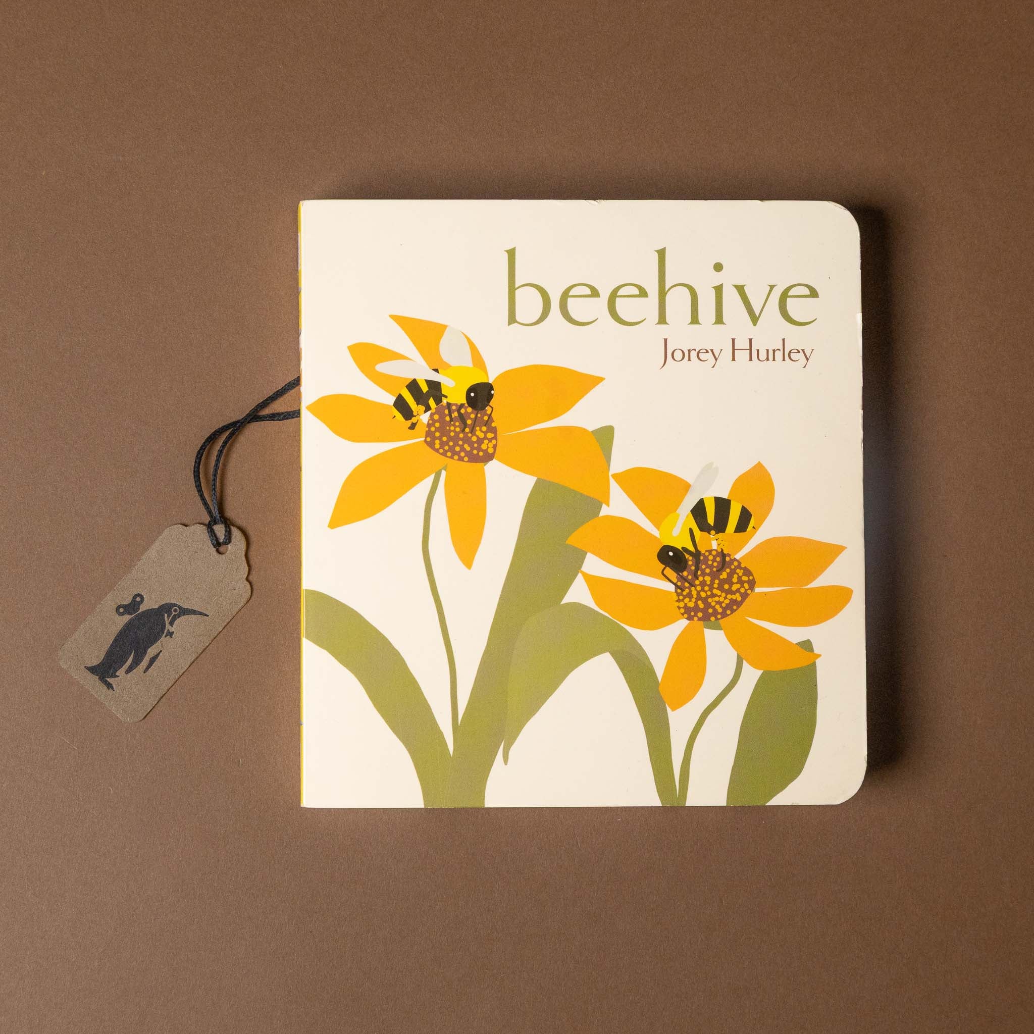 Book titled 'beehive' by Jorey Hurley with illustrations of flowers and bees on a brown background.