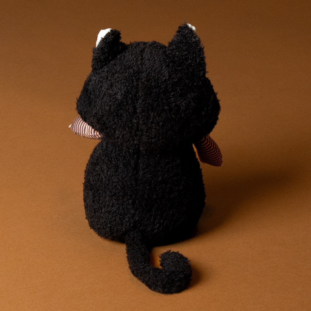 back of Black plush boo-the-cat-tail on a brown background