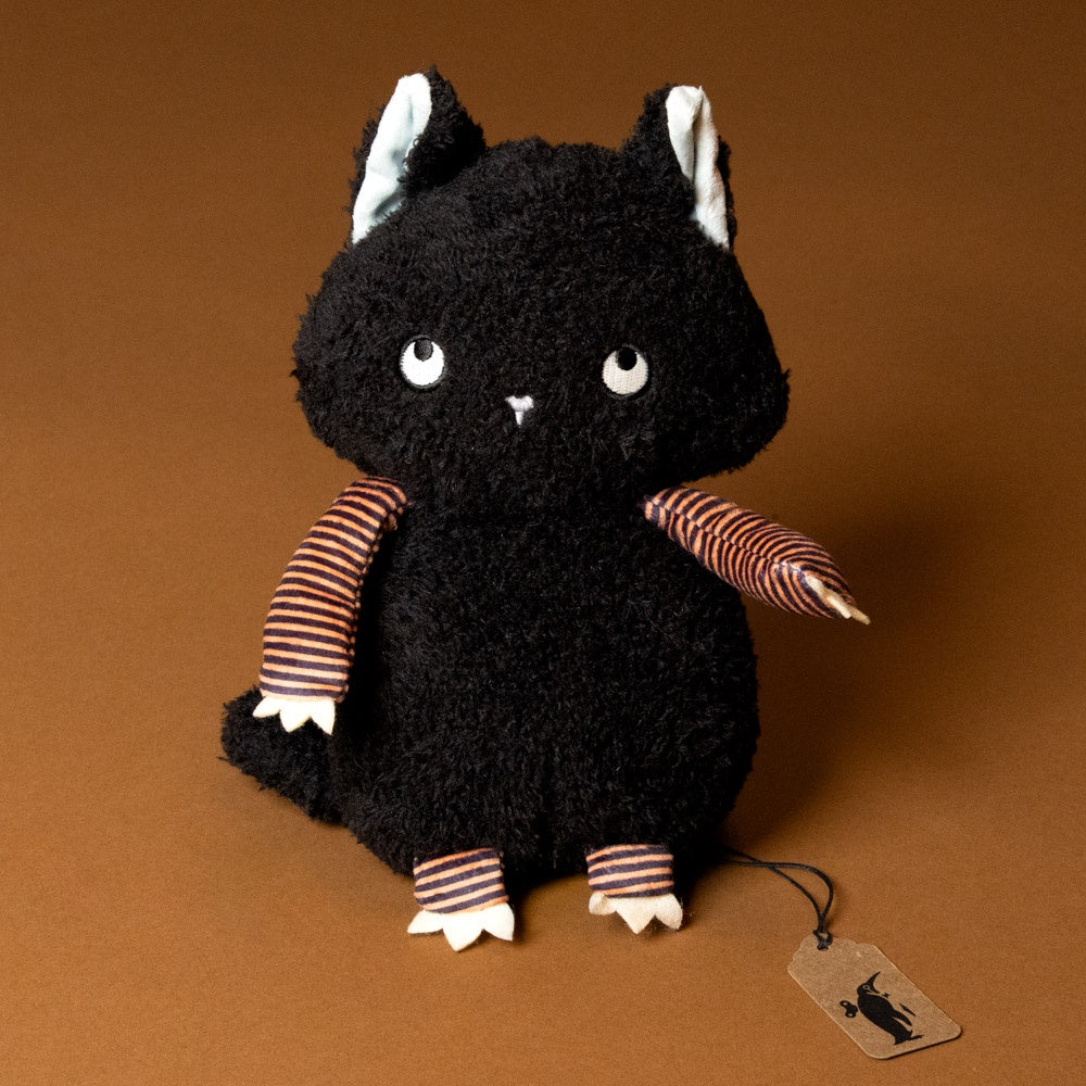 Black plush boo-the-cat with striped arms and legs on a brown background