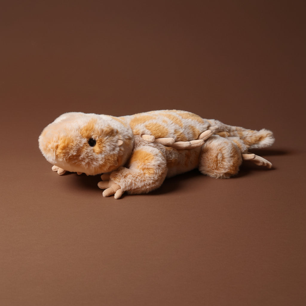Plush toy boogie-the-bearded-dragon lizard on a brown background