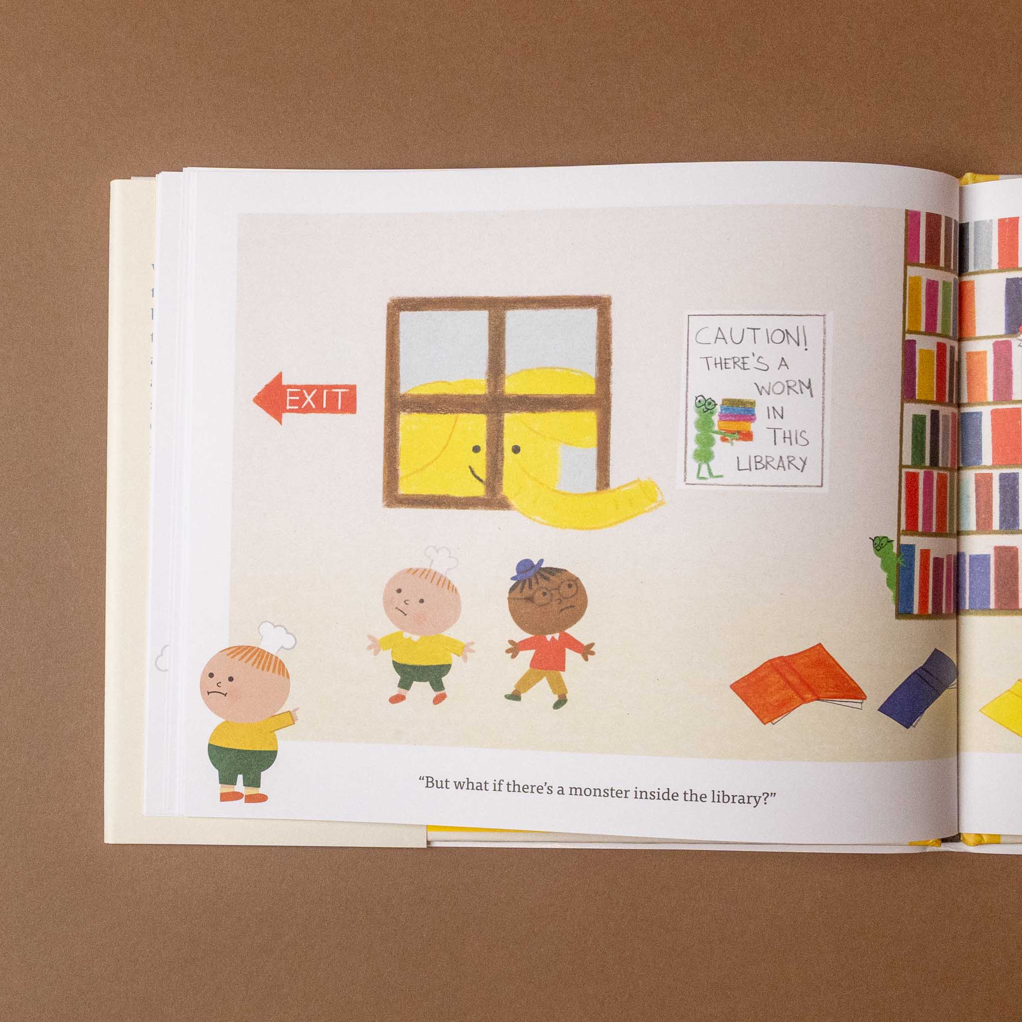 Open bookie-and-cookie-turn-the-page-book with colorful illustrations of children and a yellow elephant  in a library setting.