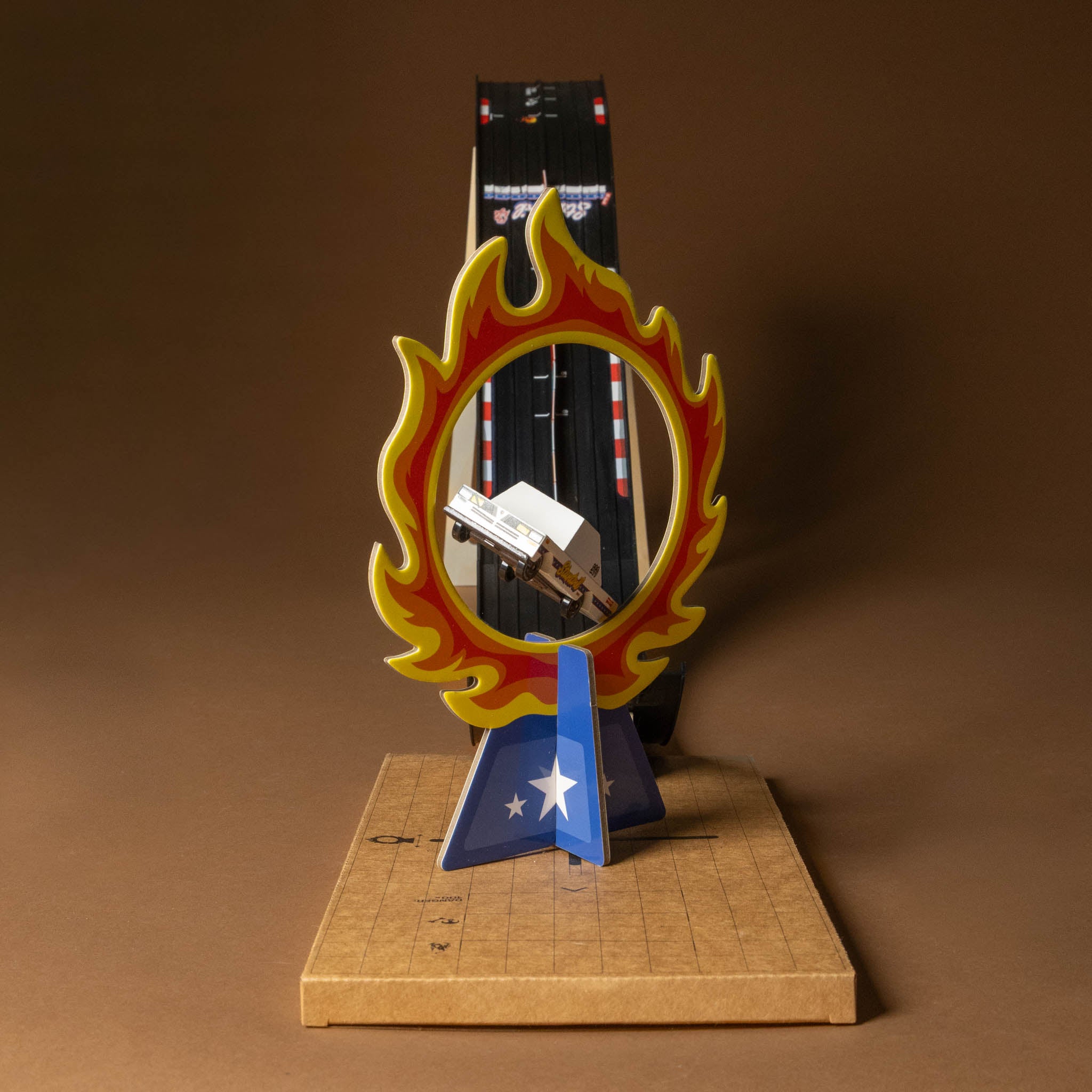 candycar-play-set-jump of a car on a stand with a flame design against a brown background