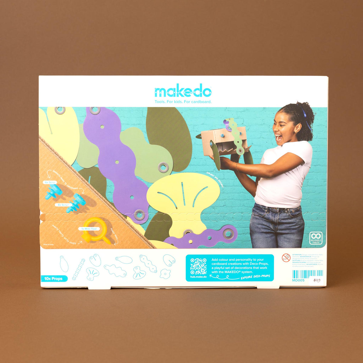 blobbies art kit packaging box, featuring a colorful illustration of a girl painting on a teal brick wall background, set against a solid brown backdrop.